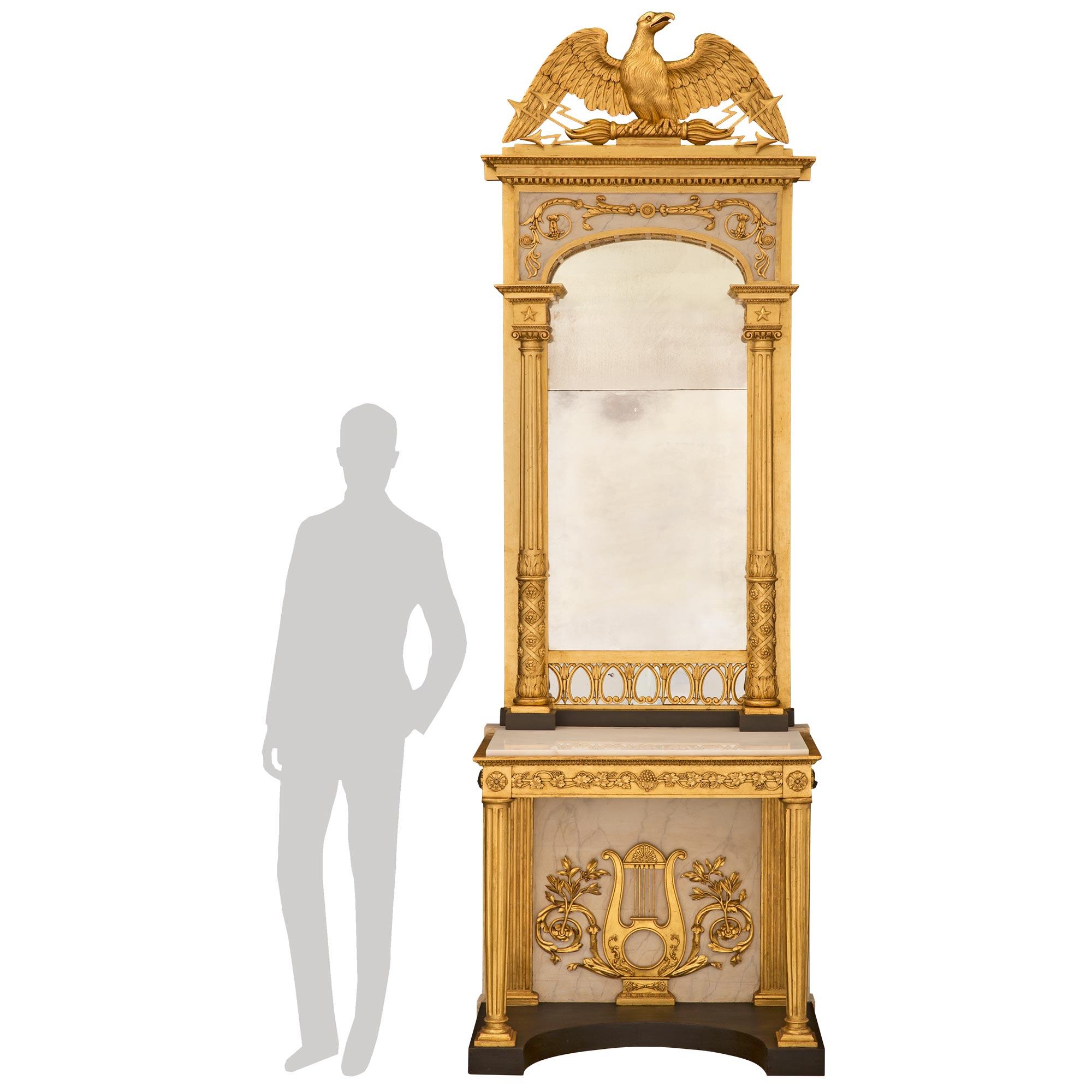A stunning Swedish 19th century Neo-Classical st. patinated, giltwood, and white Carrara marble console with its original matching mirror. The console is raised by a concave patinated black base with a wonderful patinated back panel centered by an