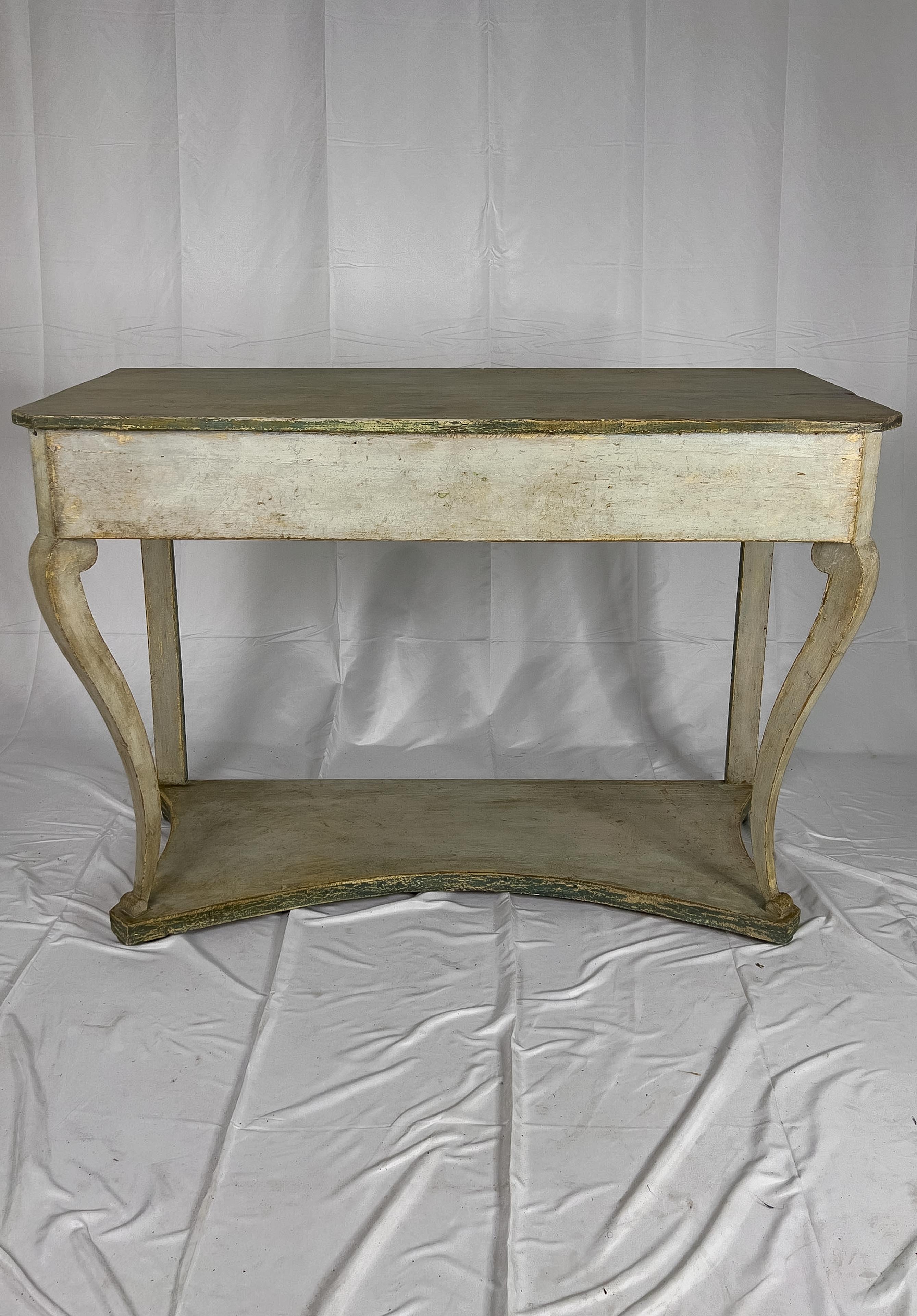 19th century Swedish painted console table supported by cabriole front legs and a base at the bottom. This piece was repainted and the top of the console is painted green while the body is in a light khaki tone. The bottom of the base and back legs