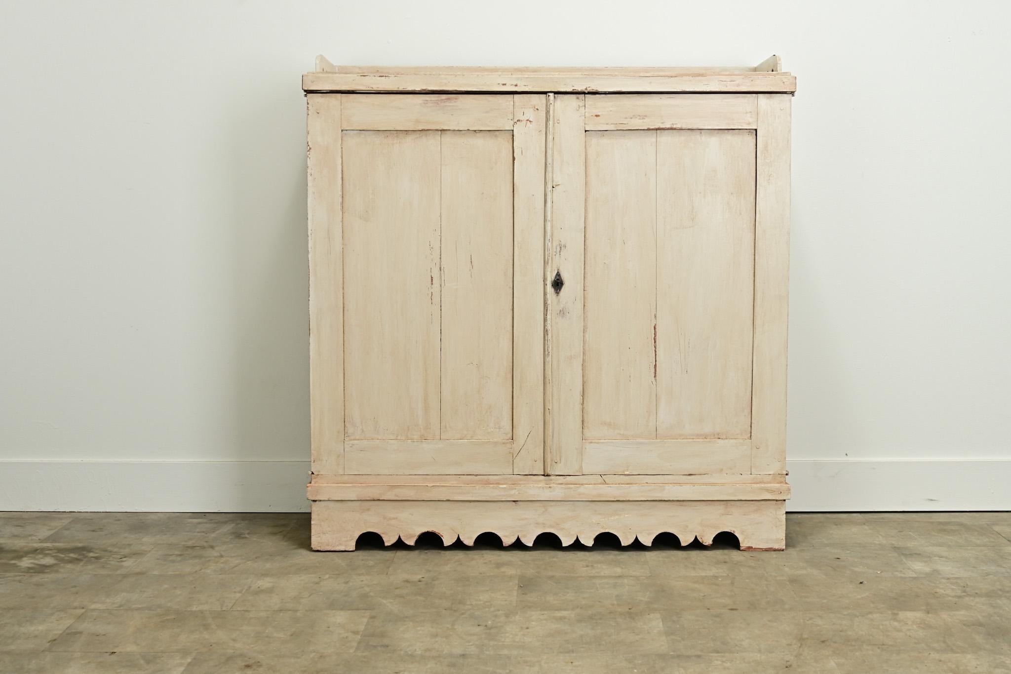 Armoire en pin peint fabriquée en Suède vers 1800. Ce meuble présente une finition peinte usée d'origine et un plateau à galerie en bois percé au-dessus d'une paire de portes à panneaux. L'intérieur est équipé de deux tiroirs et de deux étagères