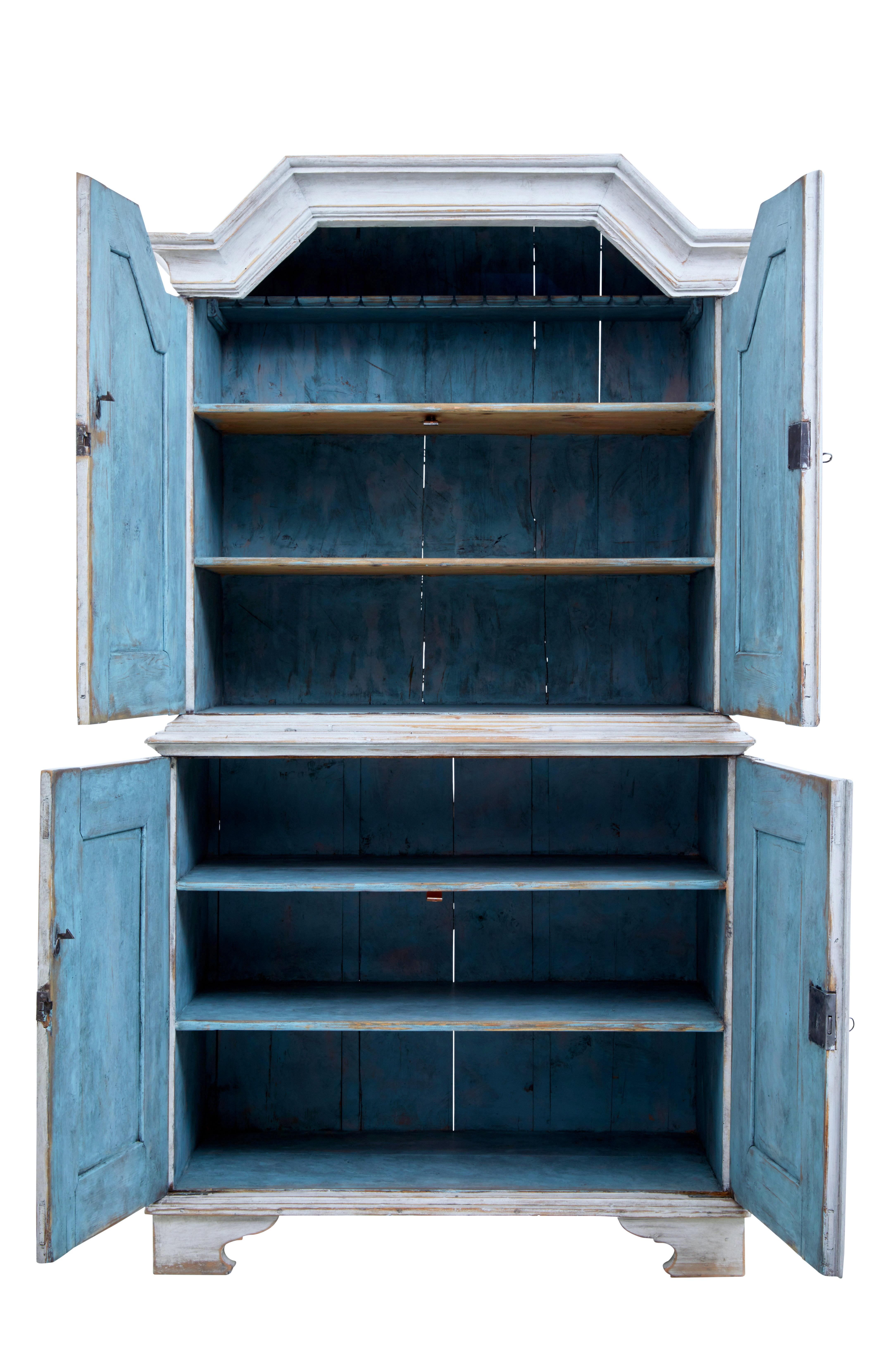 Swedish 19th century painted pine tall cupboard, circa 1860.

Top section with architectural pediment, fitted with 2 fixed shelves and a shallow storage rack. Bottom section with double doors containing 2 fixed shelves.

Original working locks