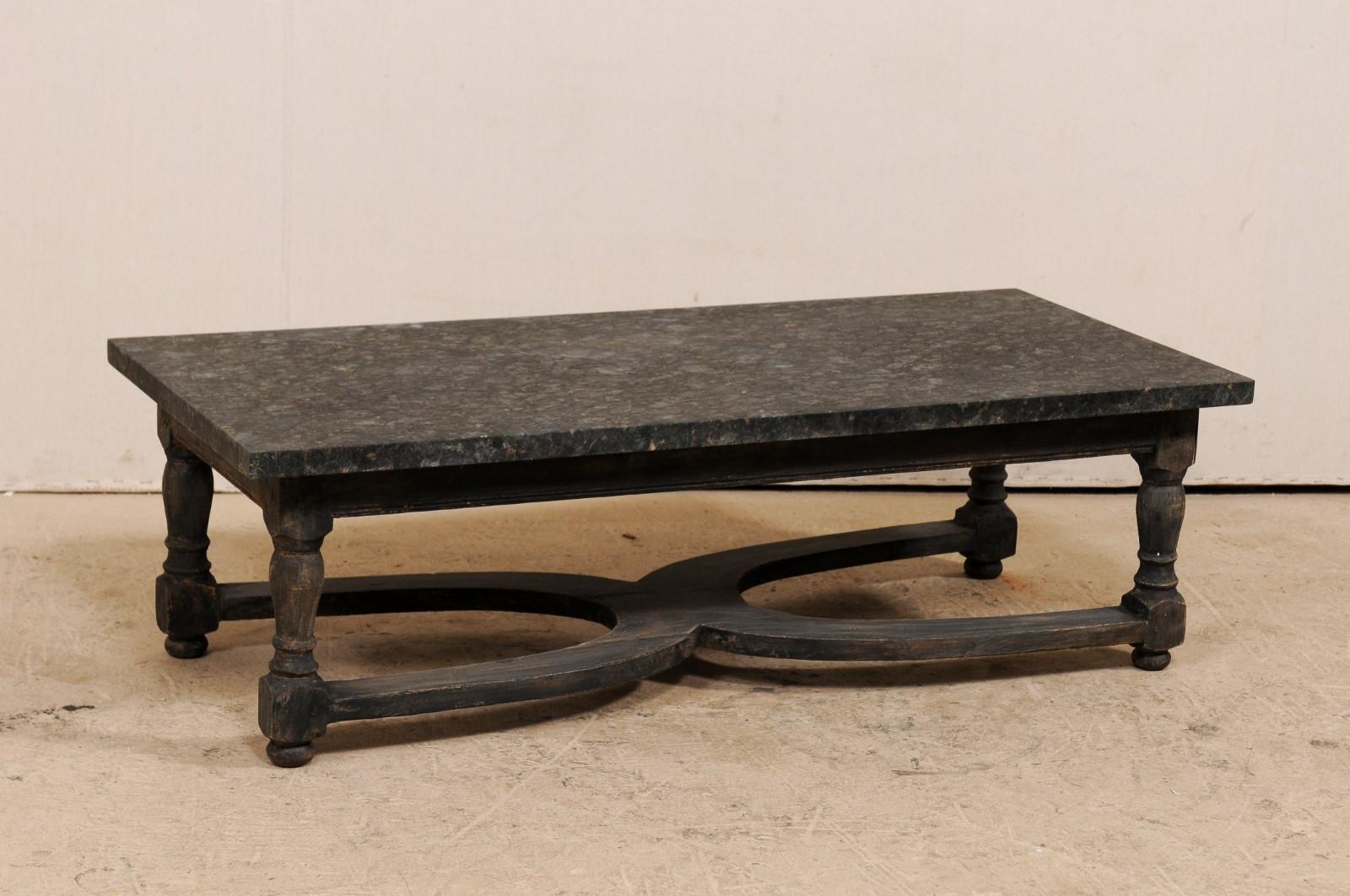 A Swedish 19th century painted wood coffee table with newer granite top. This 19th century table from Sweden features a rectangular-shape, overhanging top granite top, above a straight skirt, and has is raised up on four nicely turned legs. The