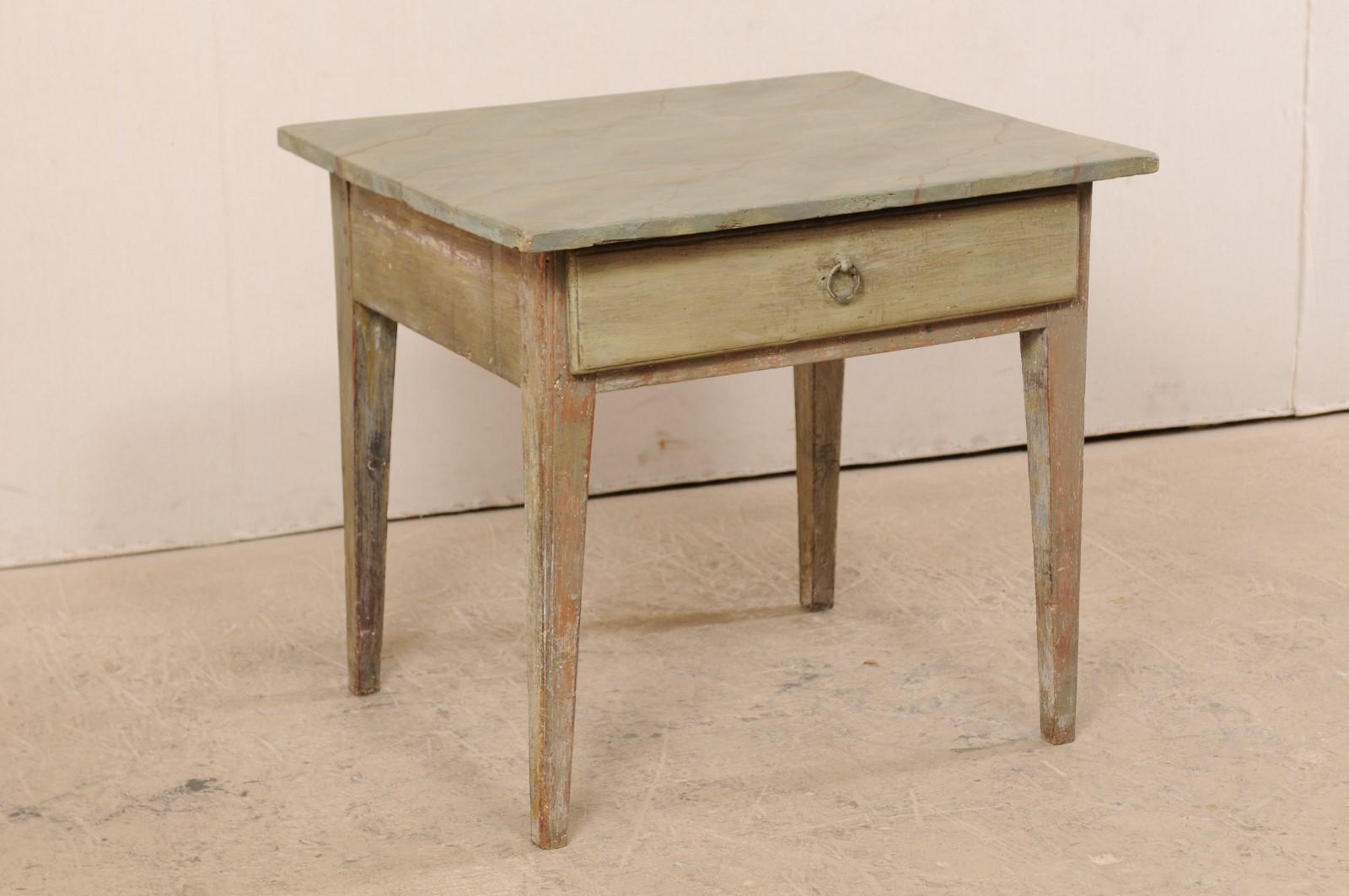 A Swedish painted wood table with faux-marble top from the 19th century. This antique Gustavian table from Sweden features a hand painted faux-marble top, which slightly overhangs a plain apron that houses a single drawer at one side. The table is