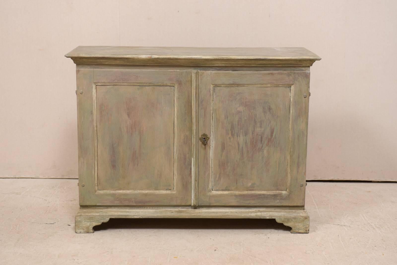 A 19th century Swedish painted wood storage cabinet. This antique Swedish two-door buffet cabinet buffet features a slightly overhanging top, over a base with two recessed panel doors, and raised on bracket feet. The two doors open to reveal three