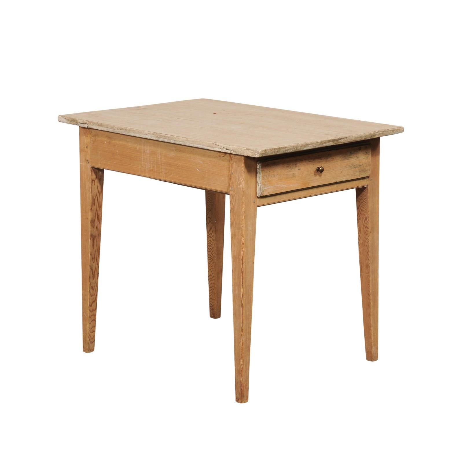 A Swedish smaller-sized wooden table, with single drawer, from the 19th century. This antique table from Sweden has a simple, unassuming design of straight lines, making it easy to blend unassumingly within many design styles in your home. The table