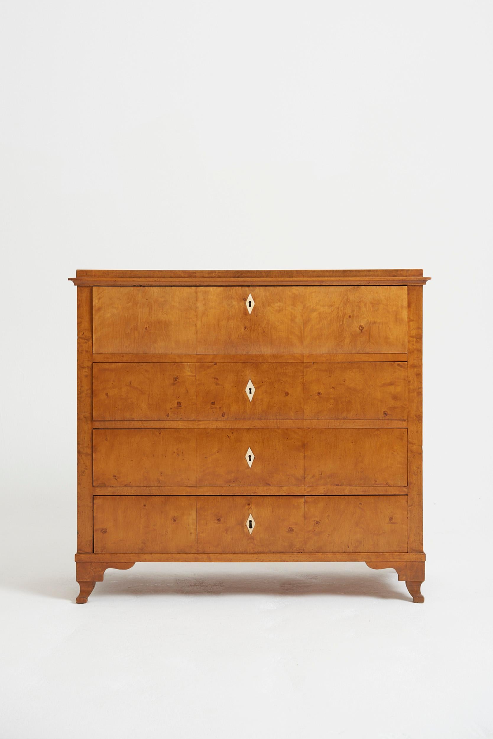 A satin birch chest of drawers, with bone key holes and knobs, the top drawer revealing a fitted secretaire. 
Sweden, Circa 1830-50