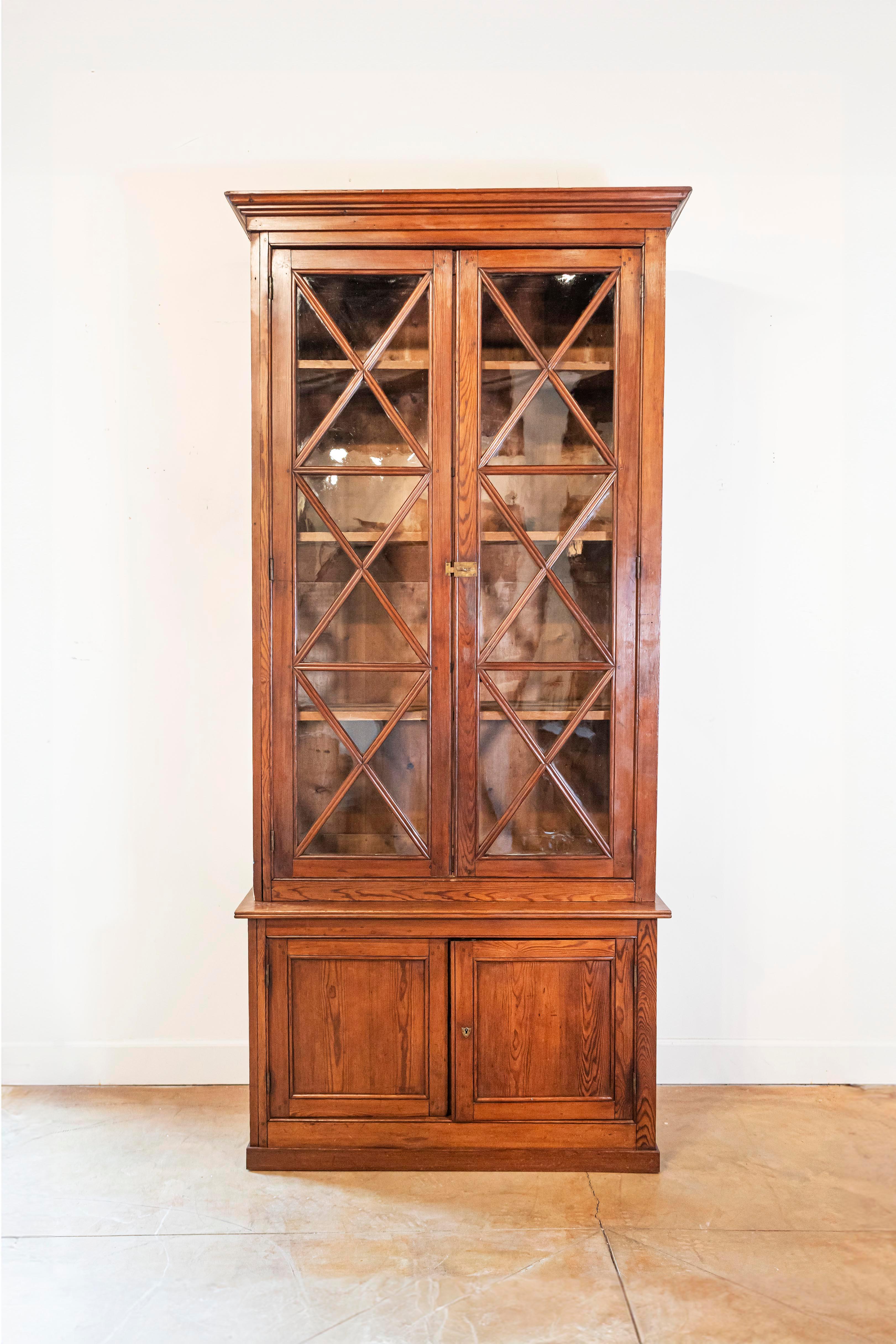 Vitrine suédoise en deux parties, en noyer, du XIXe siècle, avec de grandes portes vitrées et des motifs en forme de X. Entrez dans le monde du design suédois classique avec cette élégante vitrine en deux parties en noyer du XIXe siècle, une pièce