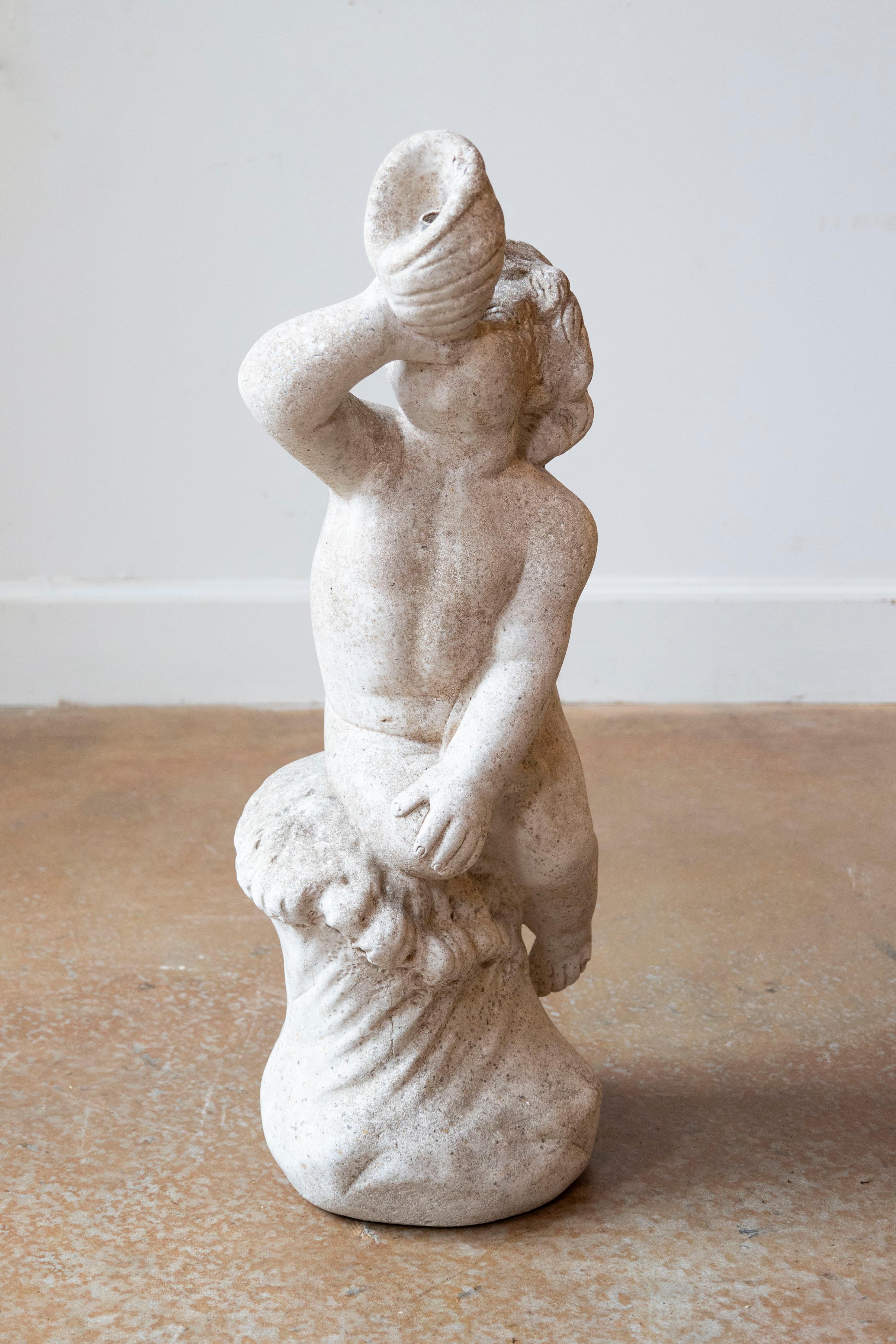 Questa statua di marmo svedese del XX secolo emana un fascino e un'eleganza senza tempo, rendendola un delizioso pezzo decorativo. La scultura raffigura un cherubino seduto in cima a una base fluida, che tiene un oggetto simile a un corno sulle