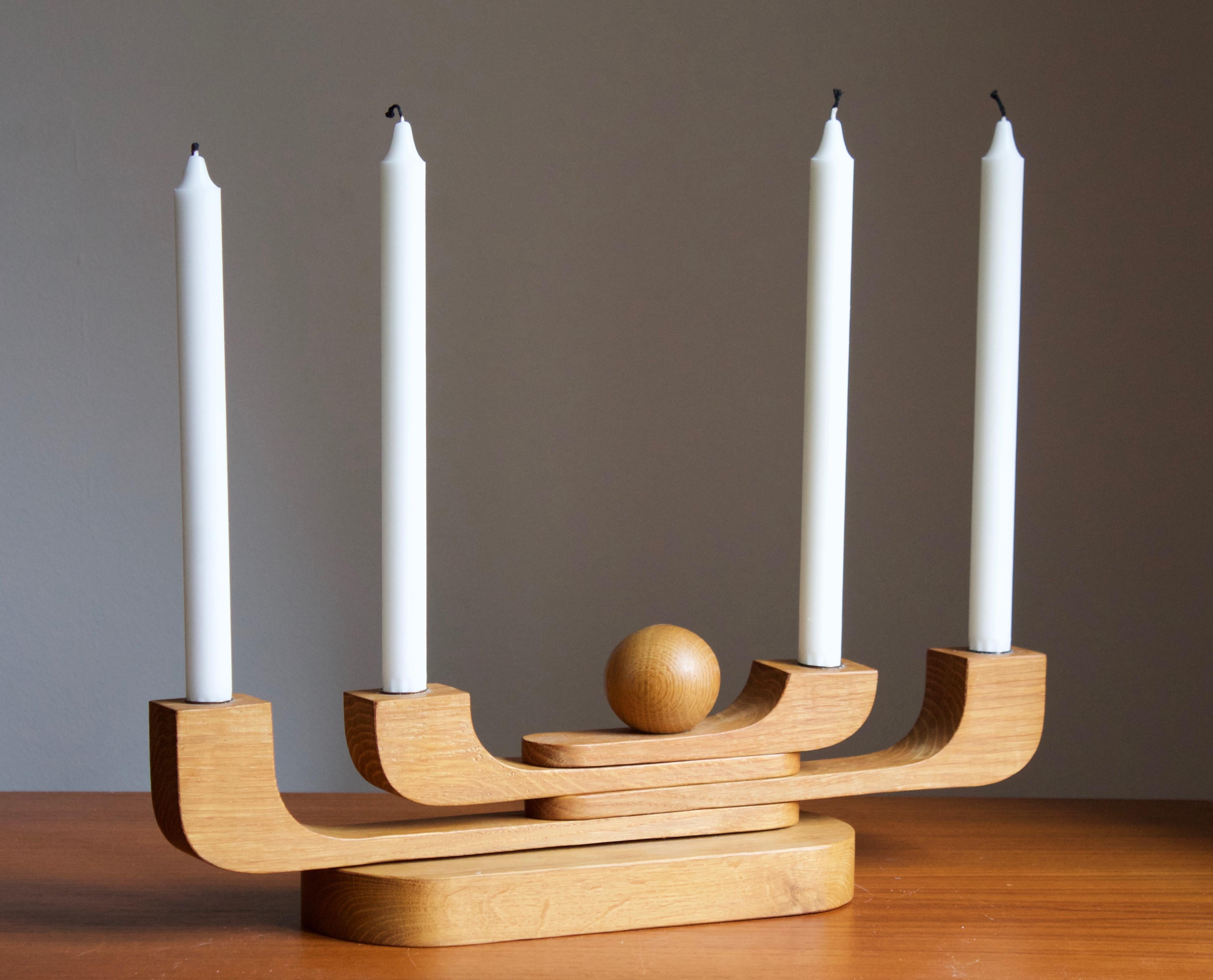 A candelabra, designed and produced in Sweden, c. 1950s-1960s. In solid oak.