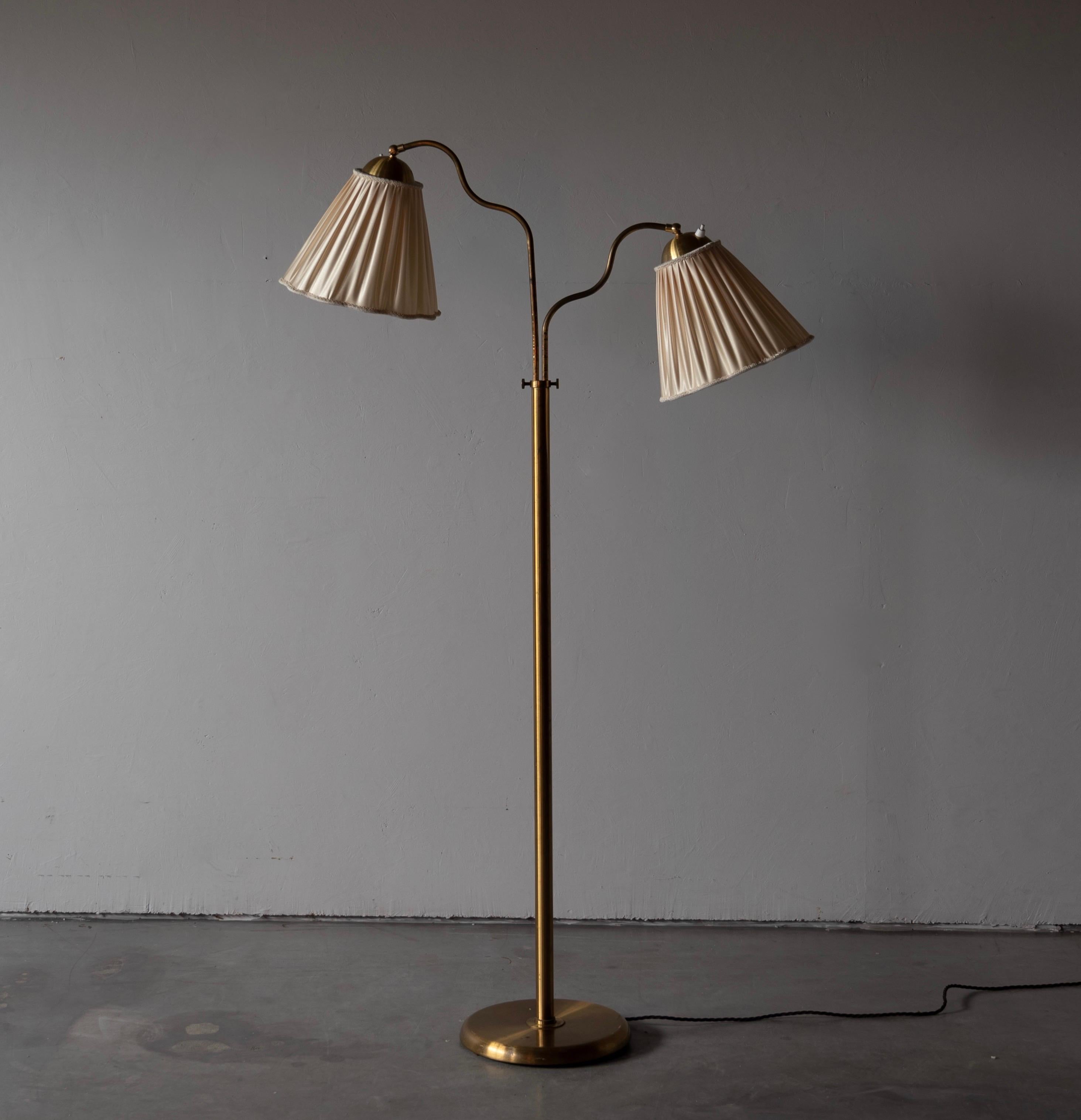 An adjustable two-armed floor lamp, designed and produced in Sweden, 1940s. brass. Brand new fabric lampshades.

Organic adjustable arm and rod, height adjustable. Brass is unpolished and has retained beautiful patina.

Other designers of the