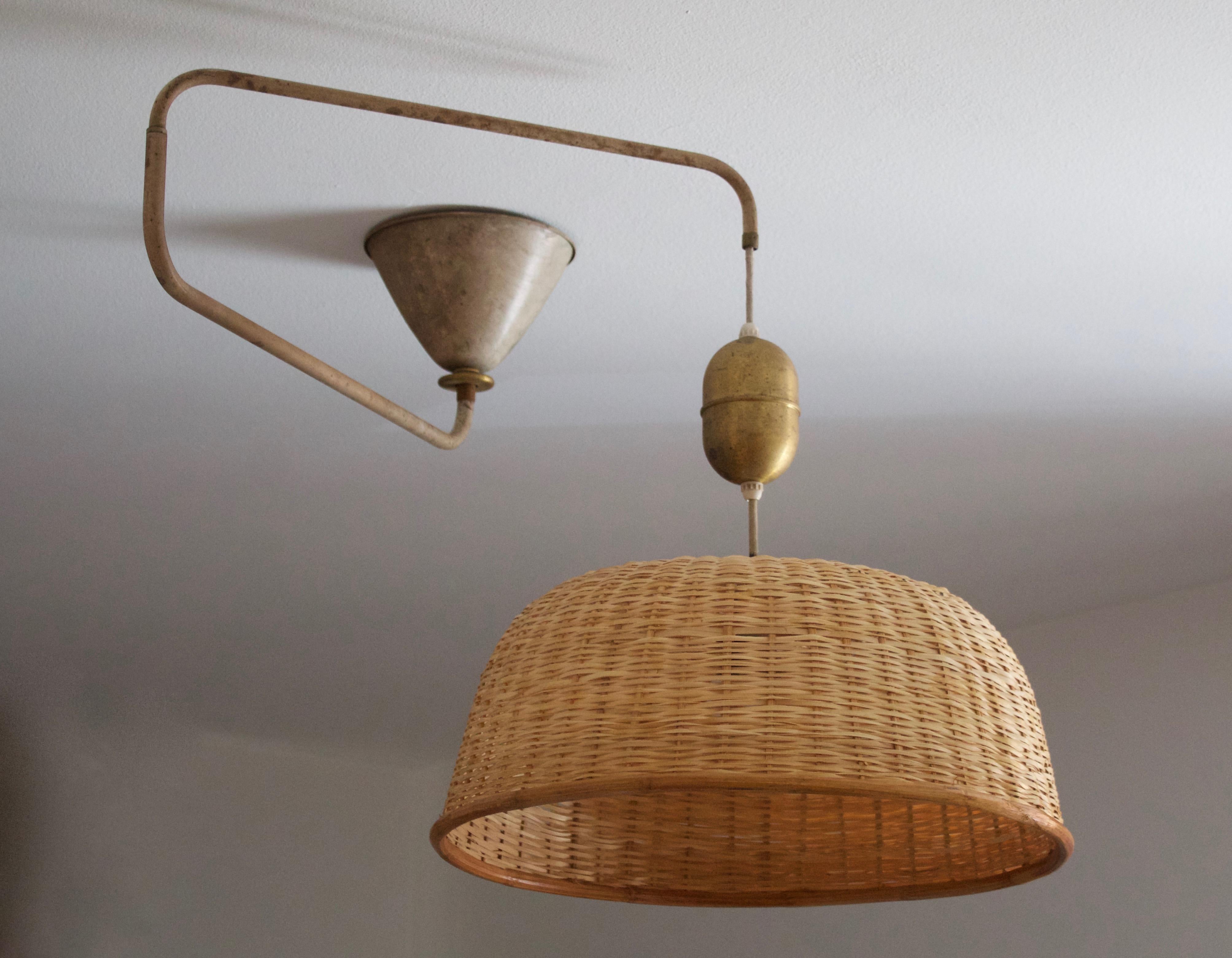 A sizable adjustable pendant light / task light. Designed and produced in Sweden, 1940s. Features an assorted vintage rattan / bamboo lampshade.

Adjustable, dimensions variable, measured as illustrated with lampshade attached.