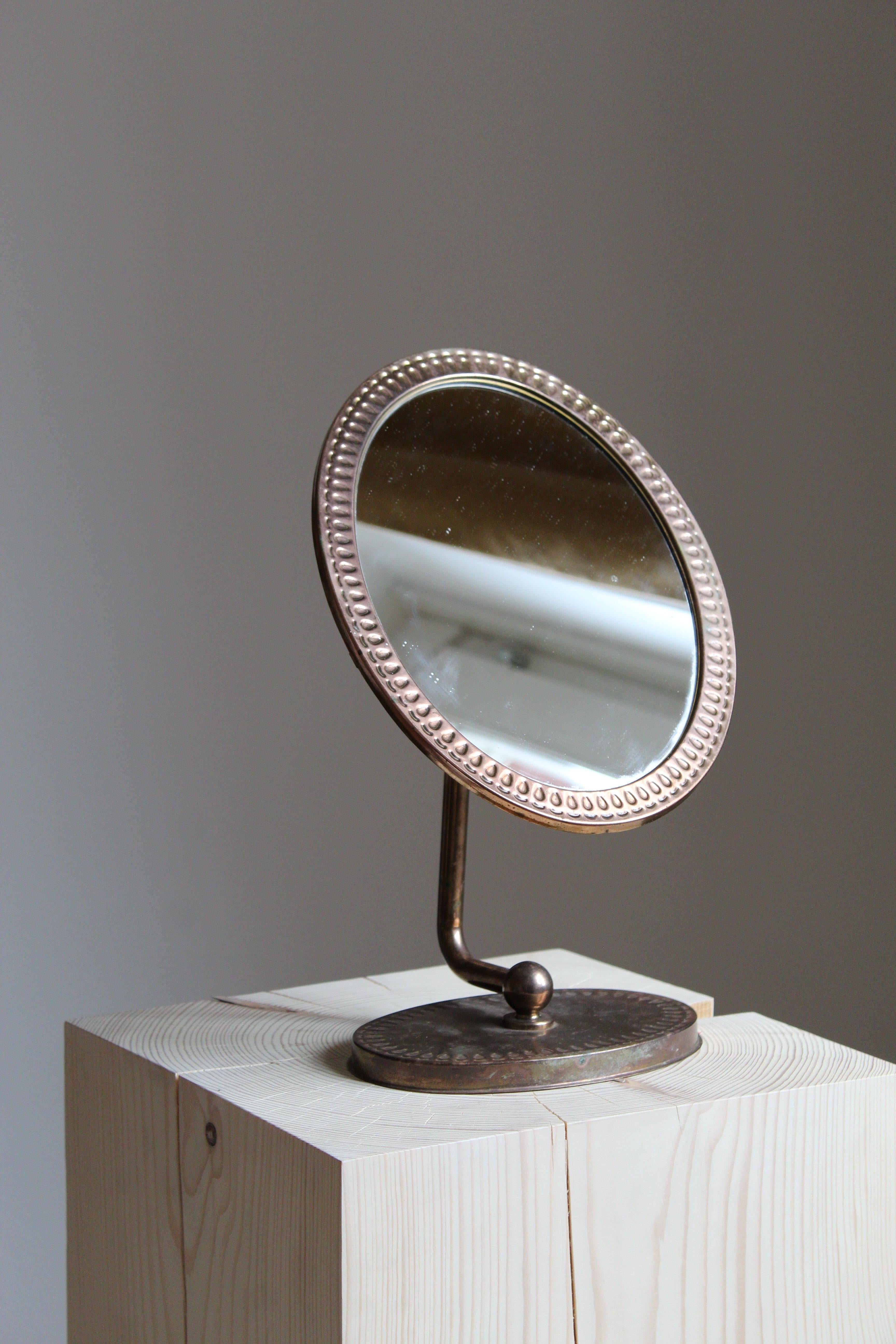 An adjustable table mirror. In copper and mirror glass. Label indicating patented Swedish design. 

 