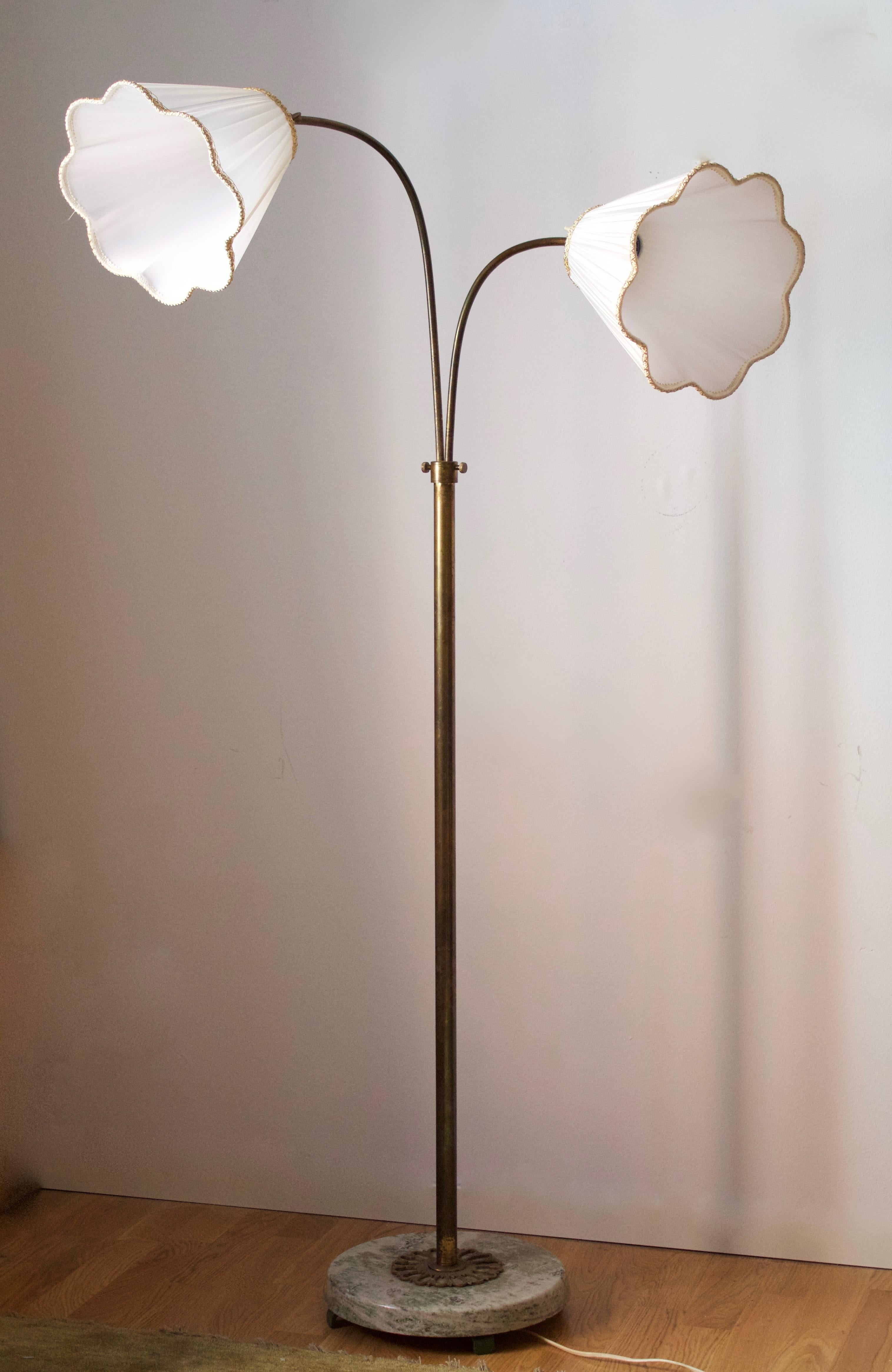 An adjustable floor lamp. Designed and produced in Sweden, 1940s. Brass with heavy marble base. Brand new lampshades of period model, handmade in Sweden.