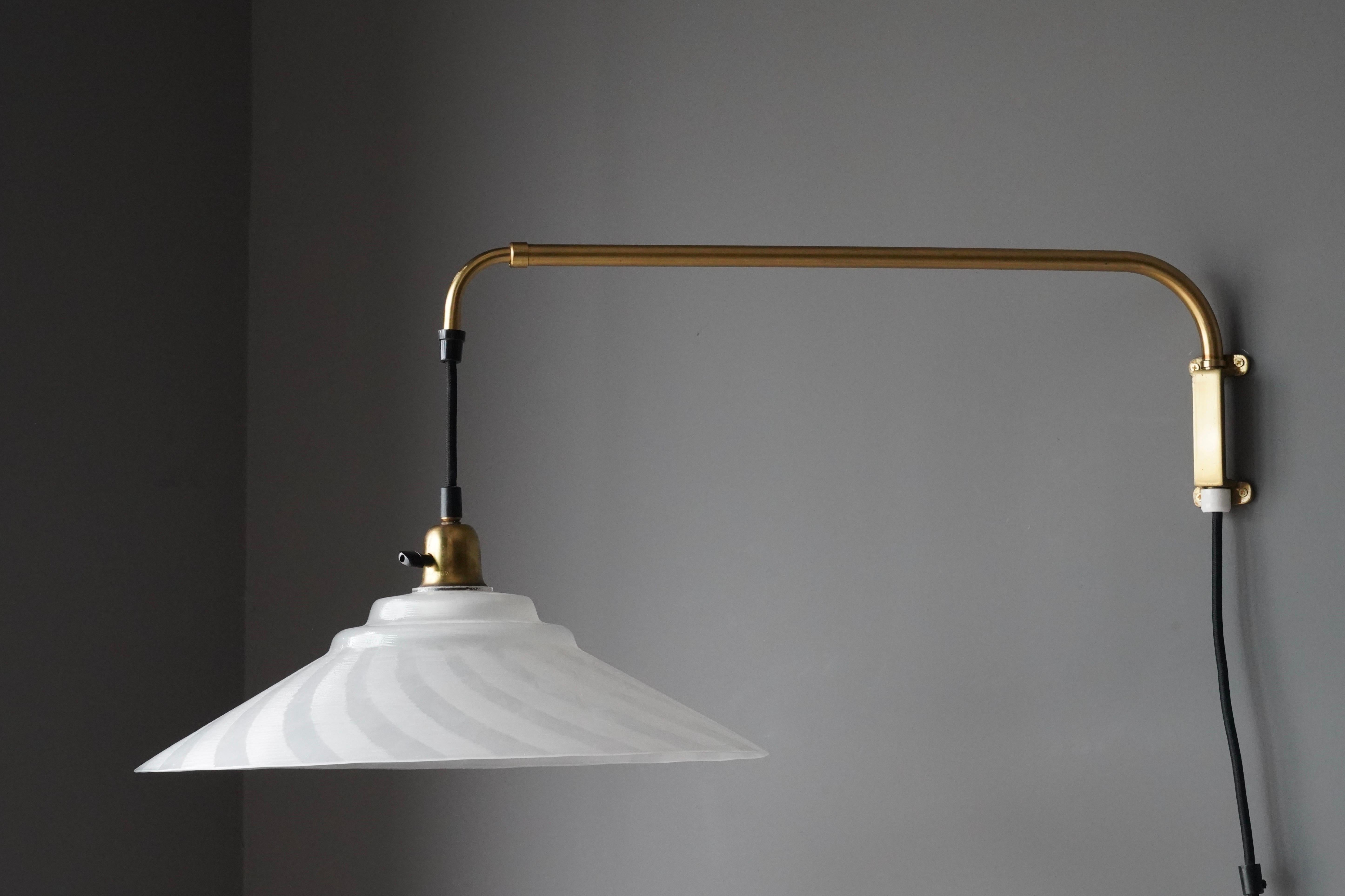 An adjustable wall light / task light. Designed and produced in Sweden, 1960s. Features brass and frosted glass. Telescopic arm.

Dimensions are measured with glass shade and when not extended. Arm extends an additional 10.5 inches.