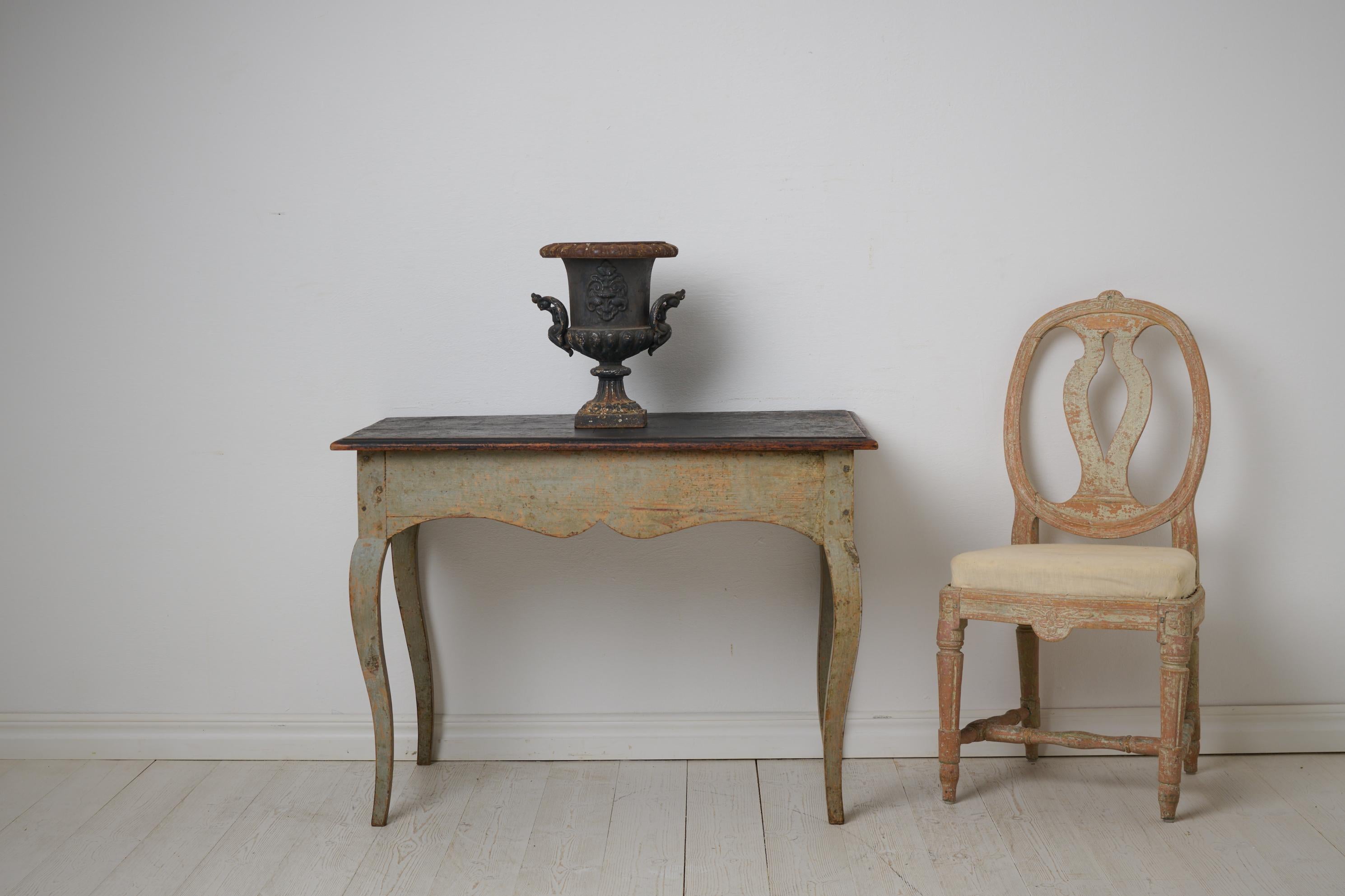 Swedish antique rococo table from the 1770s. The table has a rectangular table top with curved rococo legs and curved, bevelled aprons. Dry scraped by hand down to the original first layer of paint. The paint has patina and distress. Healthy and