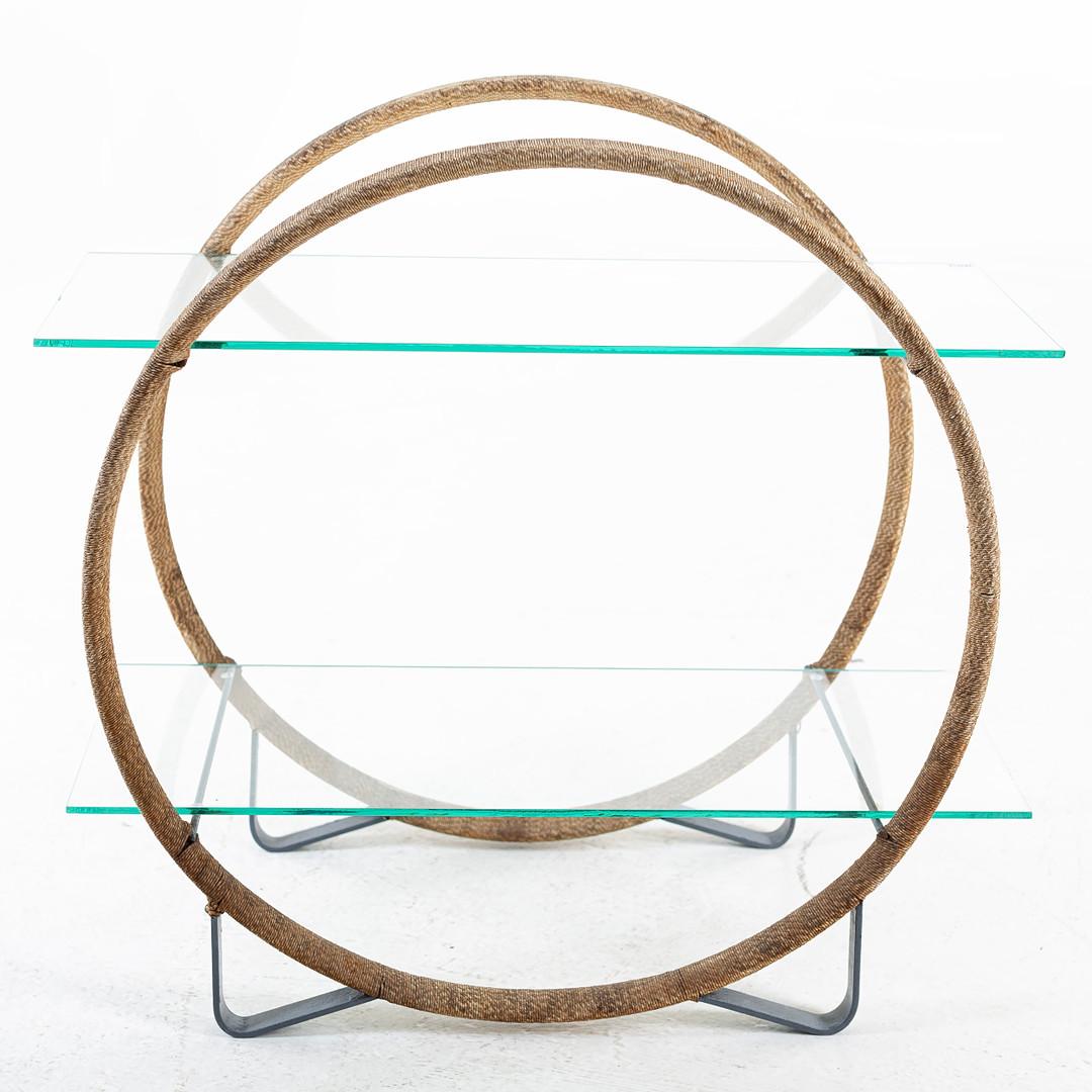 Here we have an Antique Swedish Art Deco Round Hoop Table from the early 1930s 

It features 2 hoops that are wrapped in dry seagrass type material supporting 2 glass shelves and stands on 4 metal feet.

It is a very rare and high quality Art Deco