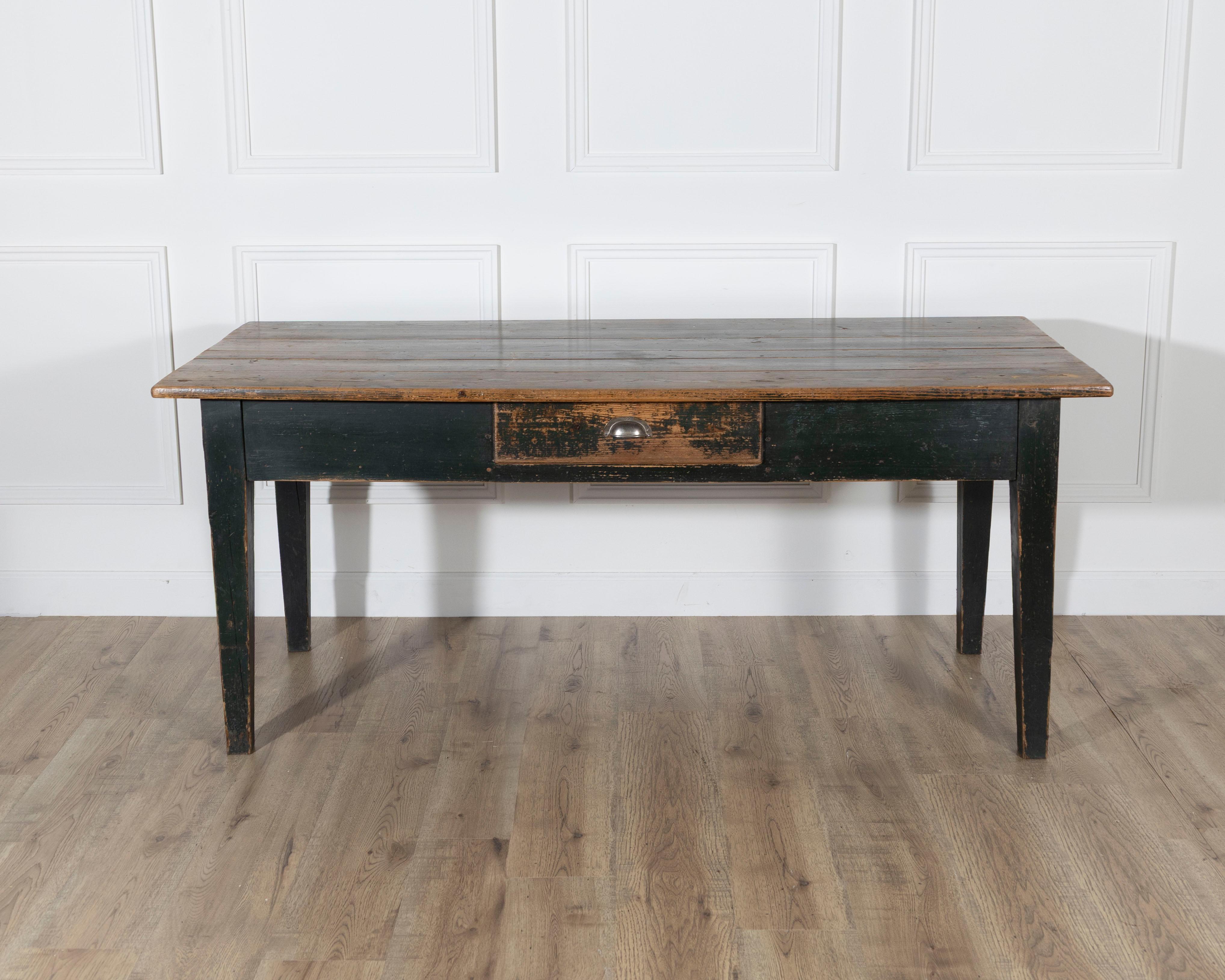 A characterful Swedish country kitchen table from the 19th century, retaining its original dark green painted finish with a rich, timeworn patina. The color remains well-preserved on the base, while the top shows remnants of the original paint, now