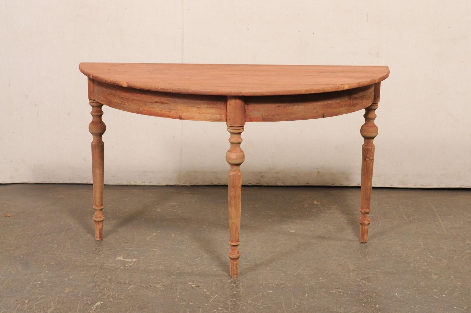 Table demi-lune suédoise en bois sculpté du début du 20e siècle. Cette table ancienne en demi-lune, originaire de Suède, présente un plateau en forme de demi-cercle ou de demi-lune, qui surplombe le tablier simple et arrondi. Cette table repose sur