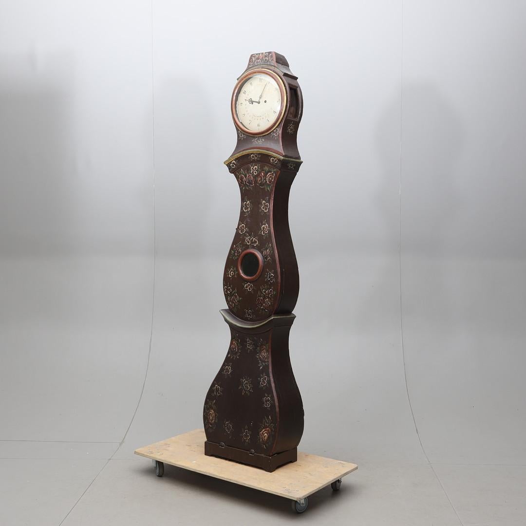 230cm  seltene frühe 1800er antike schwedische Mora-Uhr mit geschnitzten Details in einem  Volkskunst-Finish und detailliertes Gesicht  mit dem Herstellername C Palmlöf von Sala und handgemalten Details. 

Maße: 230cm.

Der Uhrenkörper ist seinem