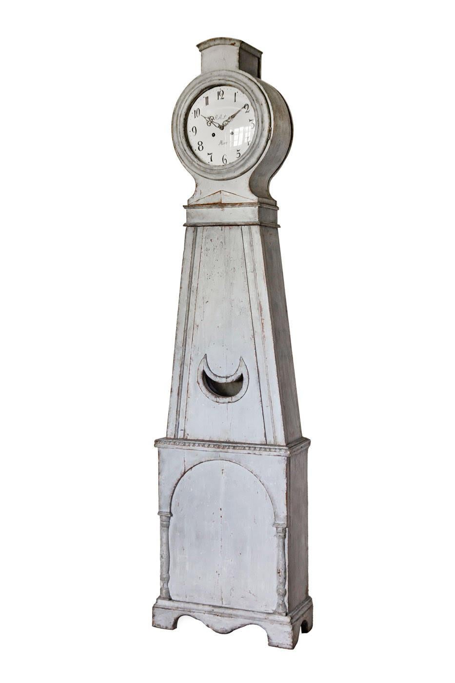 Decorative Early 1800s antique Swedish mora clock with simple detail on the hood in a white grey blue paint finish with a AAS numeral face in good condition for its age.

Measures: 207cm.

This original 1800s mora clock has a nice face and features