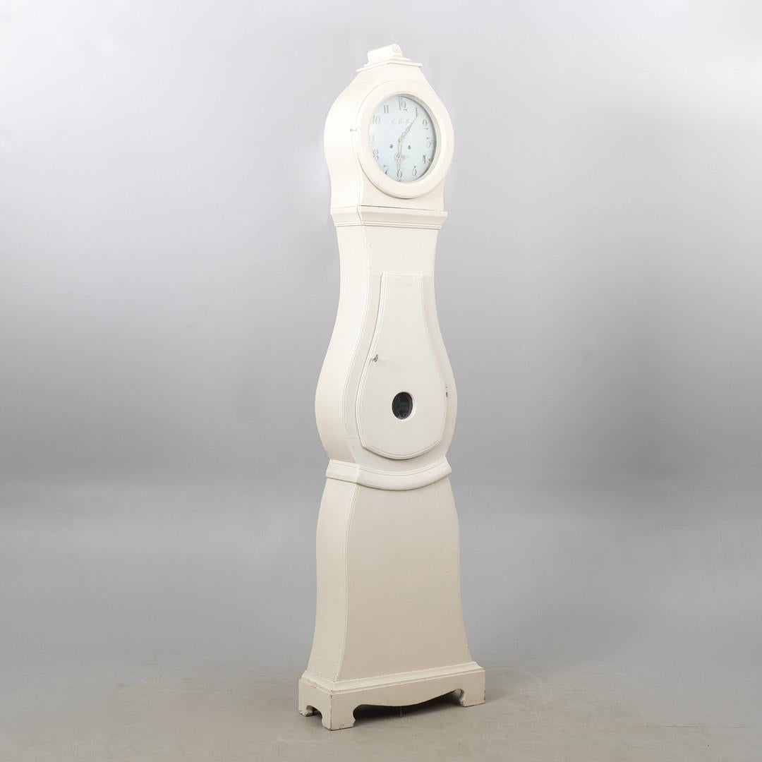 decorative early 1800s antique Swedish mora clock with simple detail on the hood in a white paint finish with a AAS numeral face.

Measures: 215cm.

This original 1800s mora clock has a nice face with a clean patina.

The clock body is