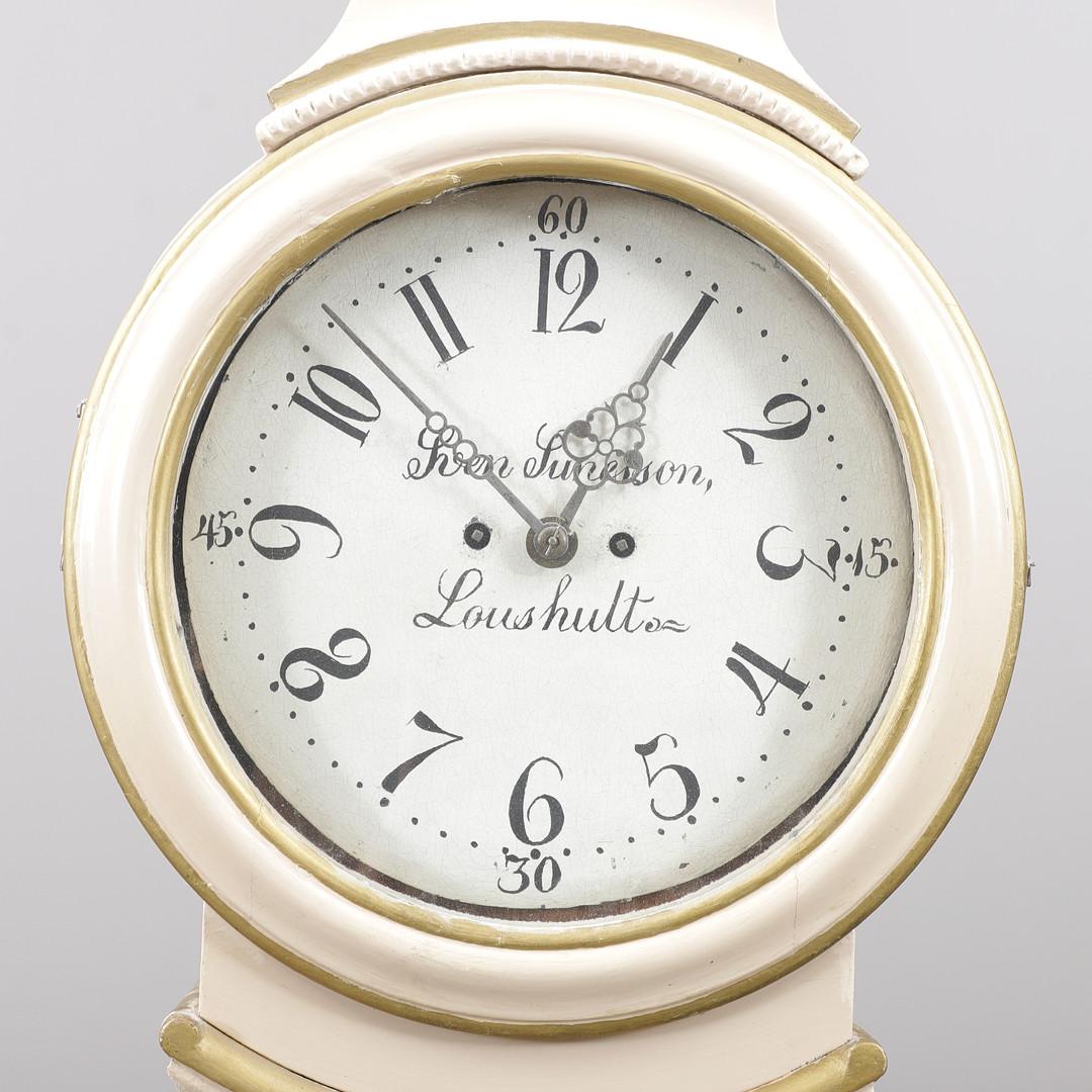 Elegant hoch 220cm  frühe 1800er antike schwedische Mora-Uhr mit geschnitzten Details auf der Haube  in weißer Lackierung und mit detailliertem Gesicht  und die Markierungen des Herstellers Sven Sunesson Loushult 

Maße: 220cm.

Der Uhrenkörper ist