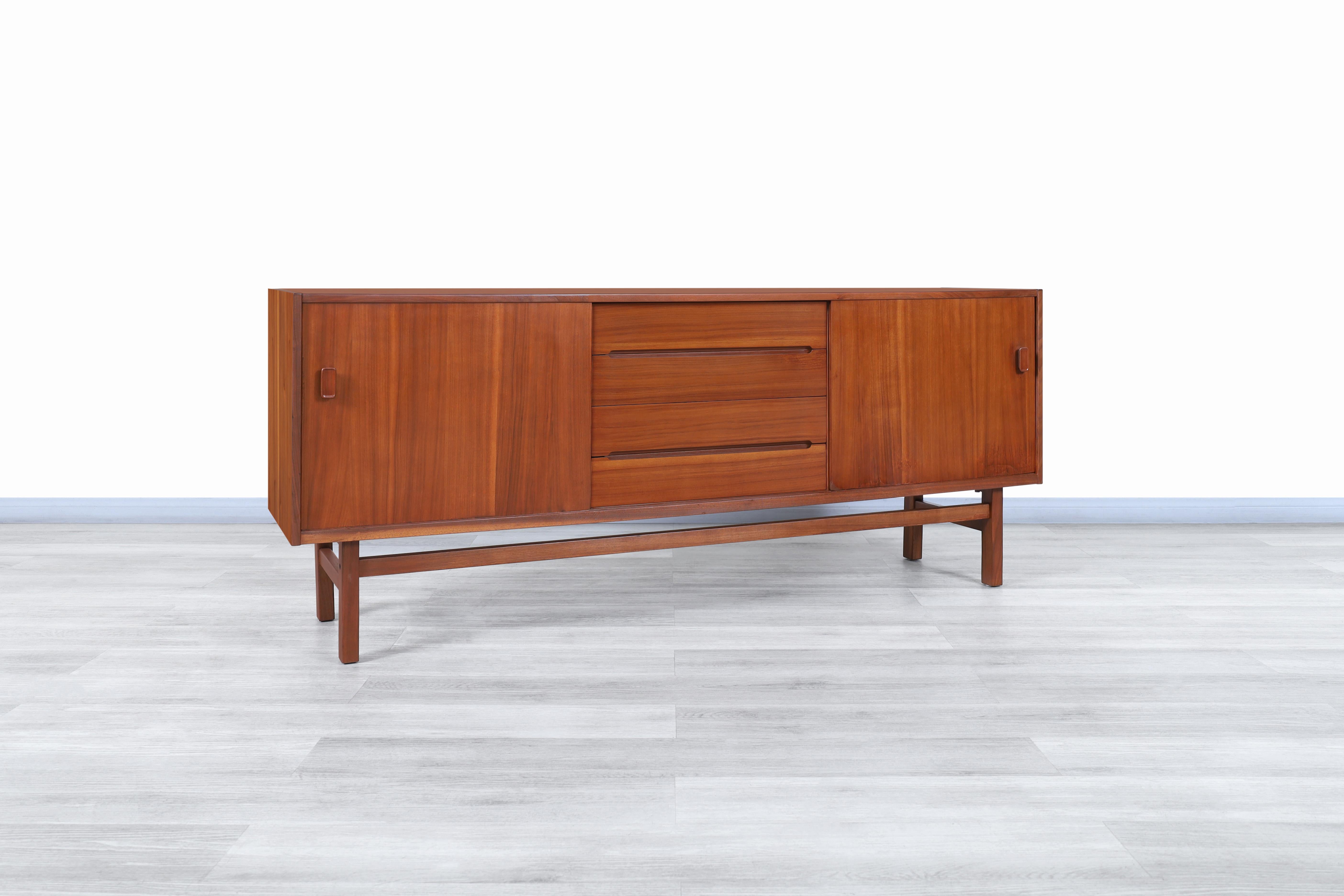 Stunning Swedish “Arild” teak credenza by Nils Jonsson for Troeds in Sweden, circa 1960s. This credenza is truly impressive since it has a minimalist design but is highly functional. It has been built from teak wood, which offers graceful colors and