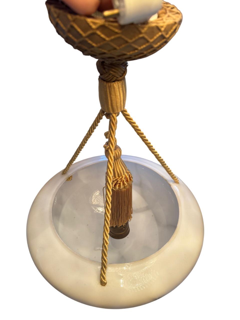 Elegante y atemporal, esta lámpara colgante sueca de la década de 1940 presenta un cuenco de cristal semitranslúcido con un patrón de vetas estilo alabastro, que evoca la refinada belleza de la piedra natural. Suspendida por intrincados detalles de