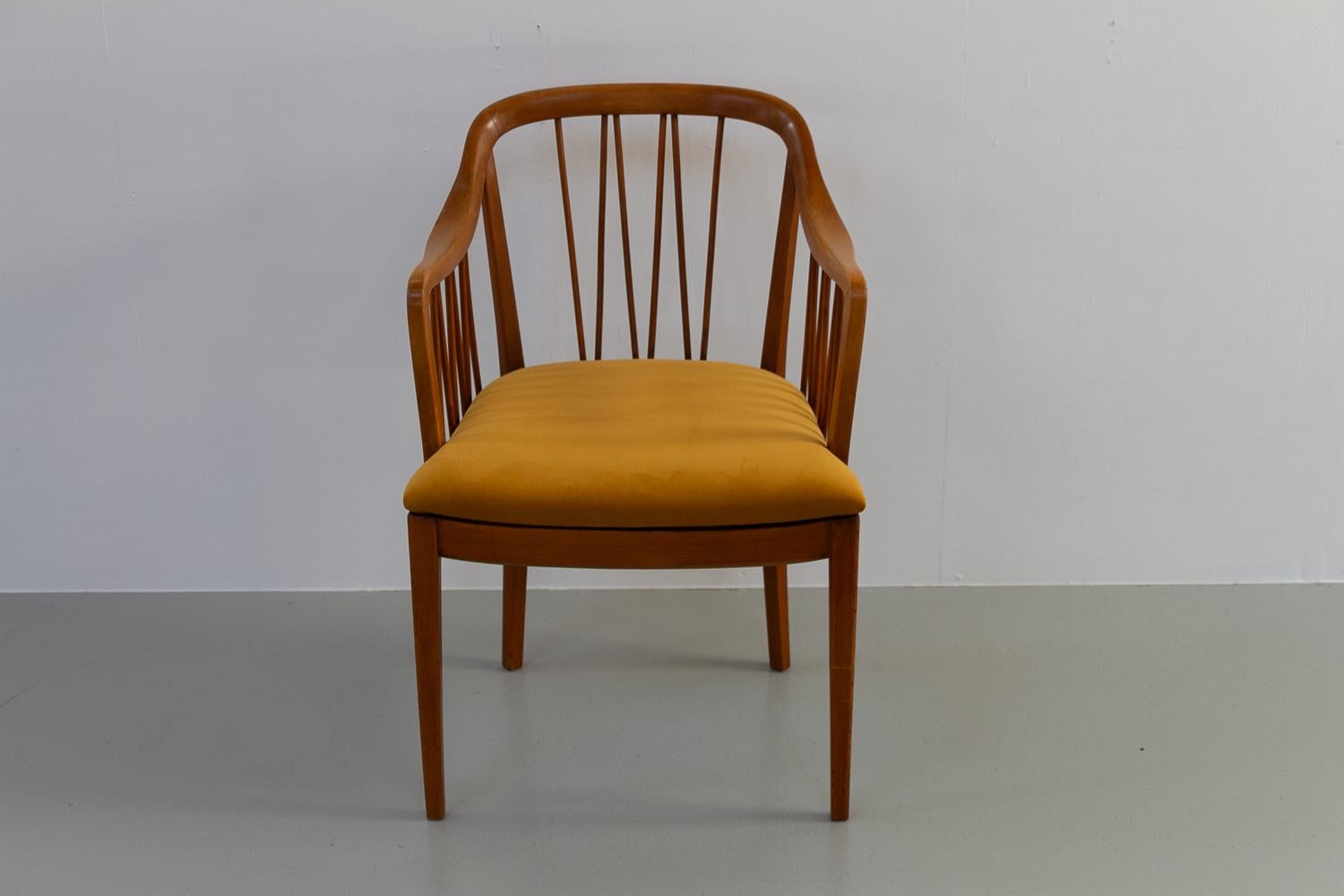 Swedish Art Deco Armchair, 1940s.

Elegant Scandinavian Art Deco armchair in stained and lacquered beech with curved backrest. Seat is newly upholstered with golden velvet fabric.
Made in Sweden by unknown manufacturer but shows some similarities to