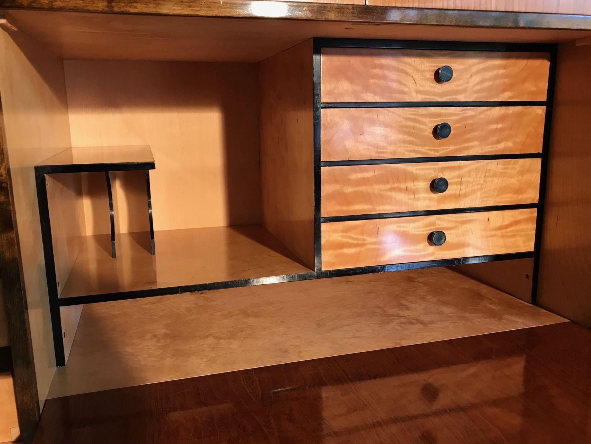 Art Deco elm, palisander and flame birch cabinet with a fitted interior that can be used as a writing desk or a bar cabinet. There are two drawers at the top and a further two drawers above the two large doors at the bottom of the cabinet. This is a