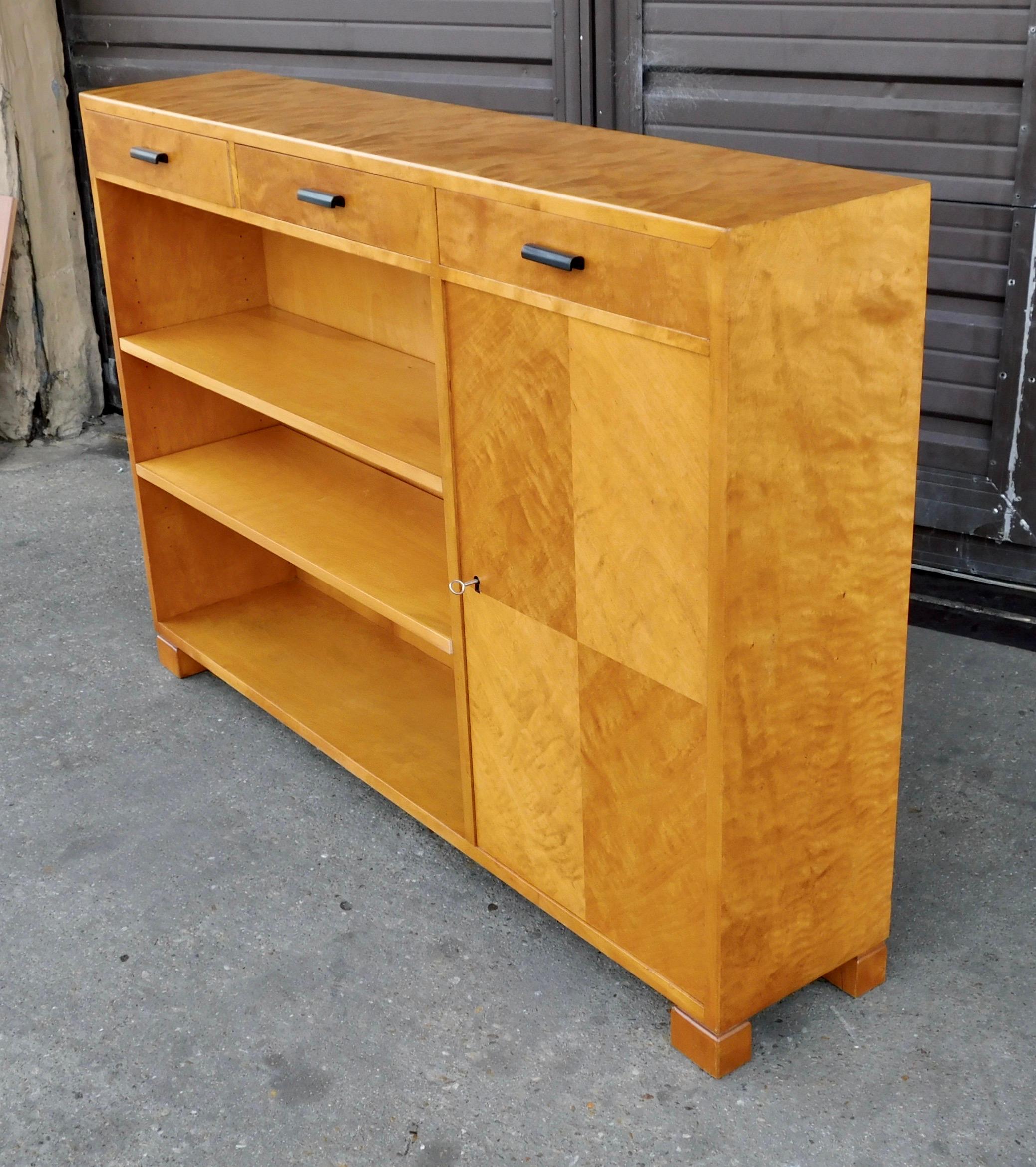Swedish Art Deco era book cabinet with removable/adjustable shelves and enclosed cabinet.
Rendered in book-matched golden flame birch wood.
With ebonized birch wood pulls.
Slim profile at 10 inches-makes this a great case for tight spaces.
The