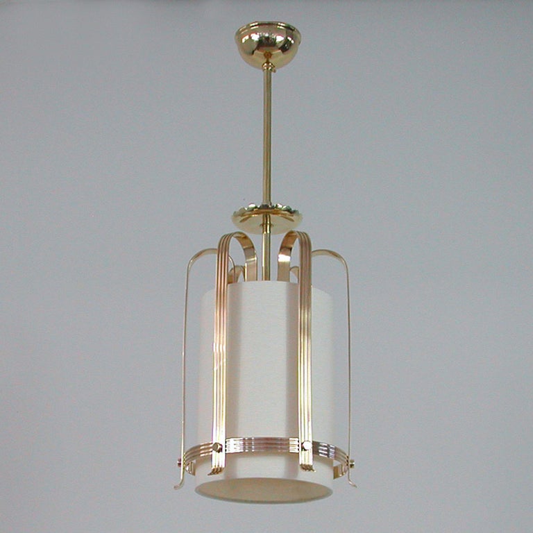 This elegant Art Deco pendant was designed and manufactured in Sweden in the 1930s to 1940s. It features an off white lampshade caged by a brass cascading lamp rack. The lampshade has been refurbished with new cotton fabric.

The lantern requires