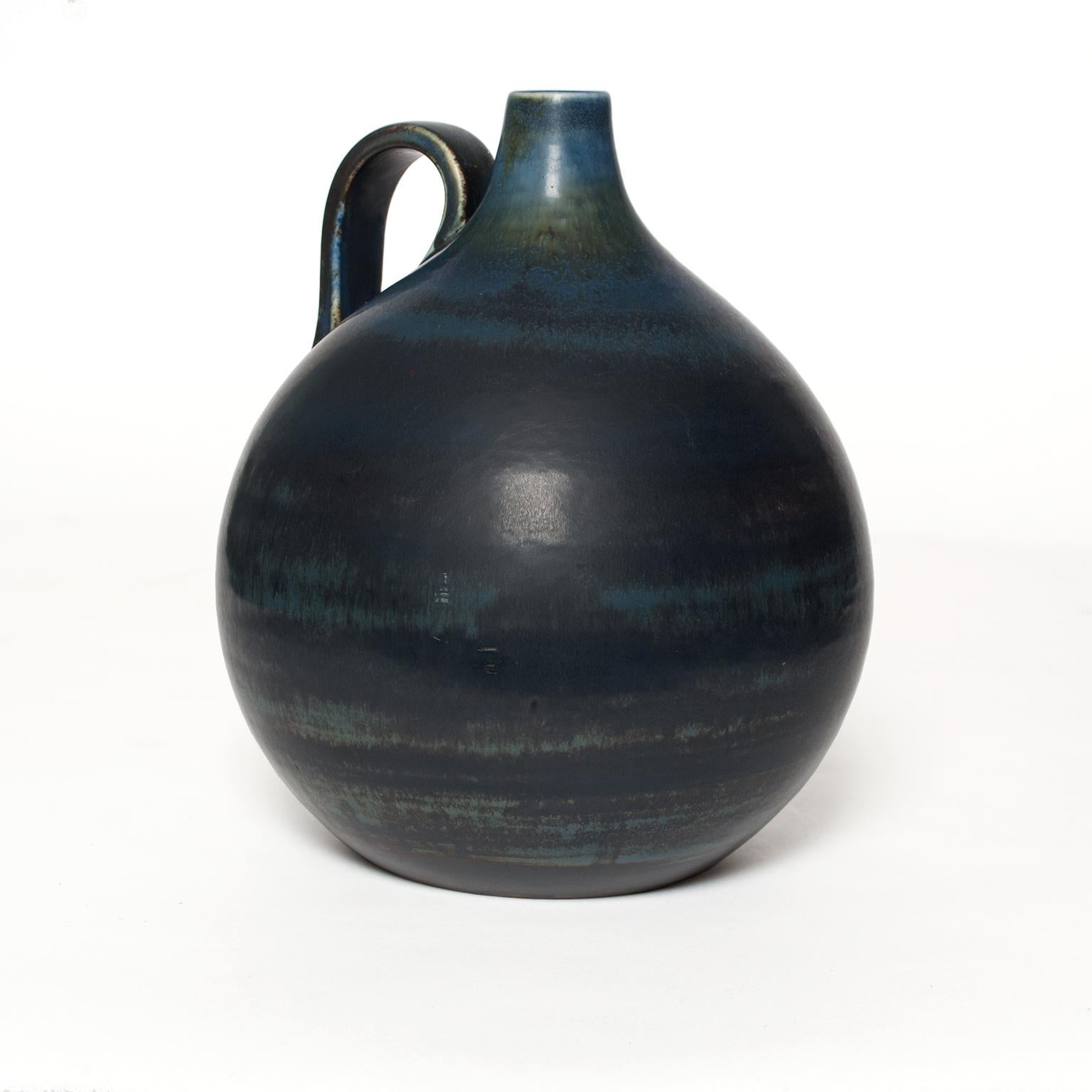 A unique Swedish art deco ceramic vessel with handle finished in a range of medium to deep blues. Made by Gertrud Lonegren for Rorstrand.
Measures: Height 10