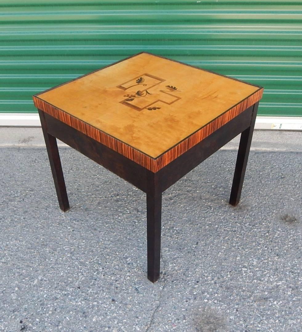 Swedish Art Deco inlaid side/end table rendered in birch wood with ebonized base.
Top in golden flame birch wood with rosewood, elm and ebony inlay. Sweden, 1930.