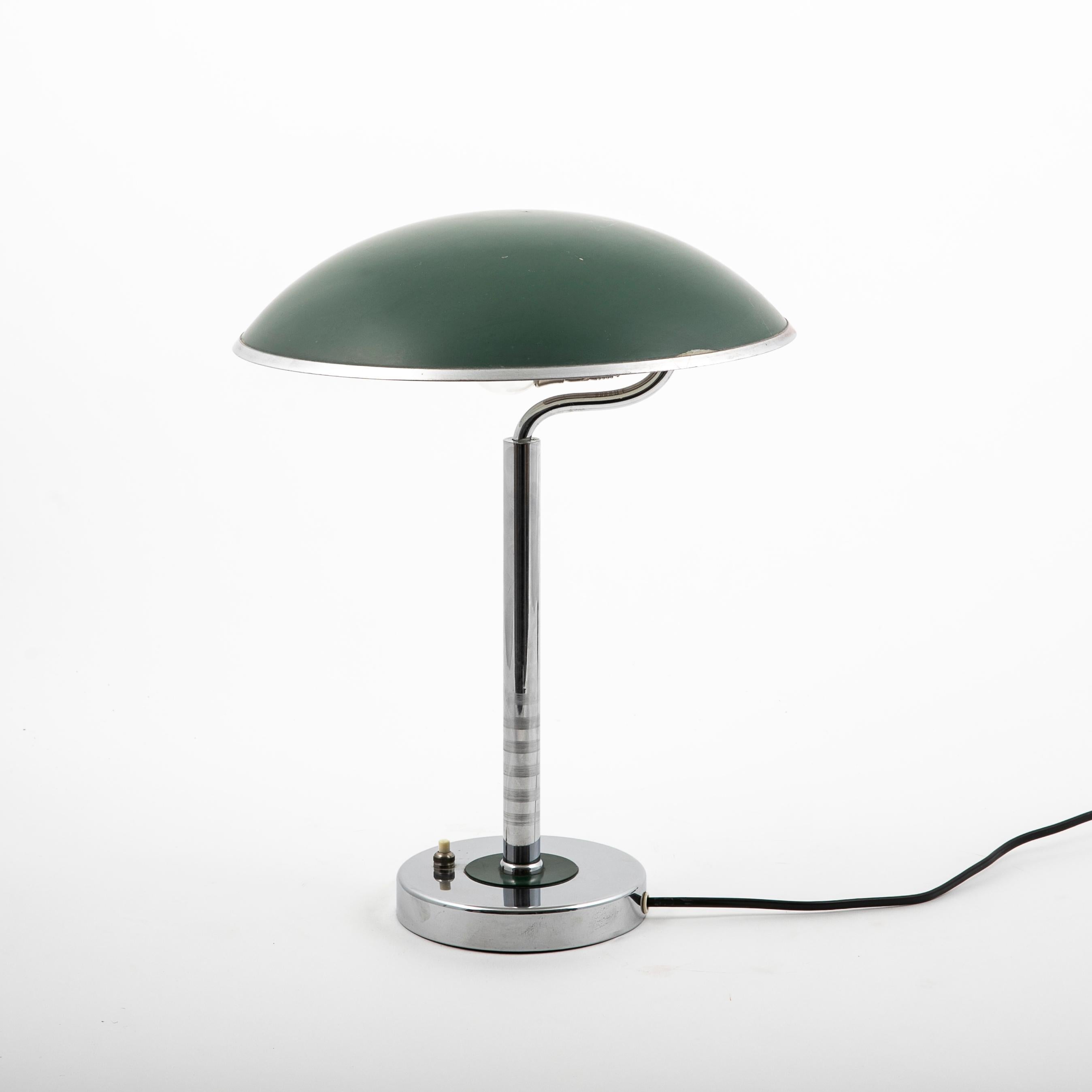Une lampe de bureau suédoise art déco en laiton chromé.
Le style Bauhaus.
Abat-jour sphérique vert peint en blanc à l'intérieur.
Diamètre de l'abat-jour : 29 cm.
Base avec anneau vert à la tige. Interrupteur marche/arrêt à la base.
État original et