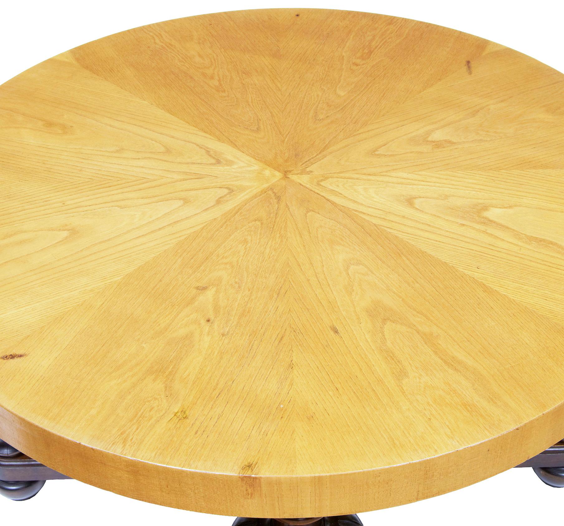 Swedish Art Deco elm and birch coffee table, circa 1930.

Segmented elm circular top surface, standing on 4 bulbous and fluted legs, united by an X-frame stretcher. Standing on turned feet.

Minor restorations to veneer.
   