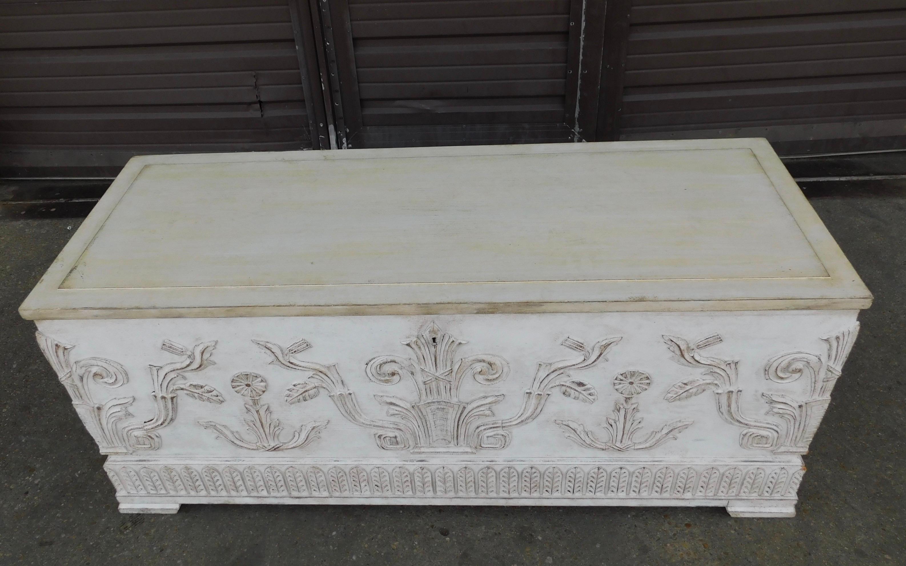 Swedish Art Deco era storage chest painted in the Gustavian manner. Milk-paint finish over oak. With neo-classically inspired high relief on front and sides. With original metal handles at sides. Loads from top. Sweden circa 1920.
