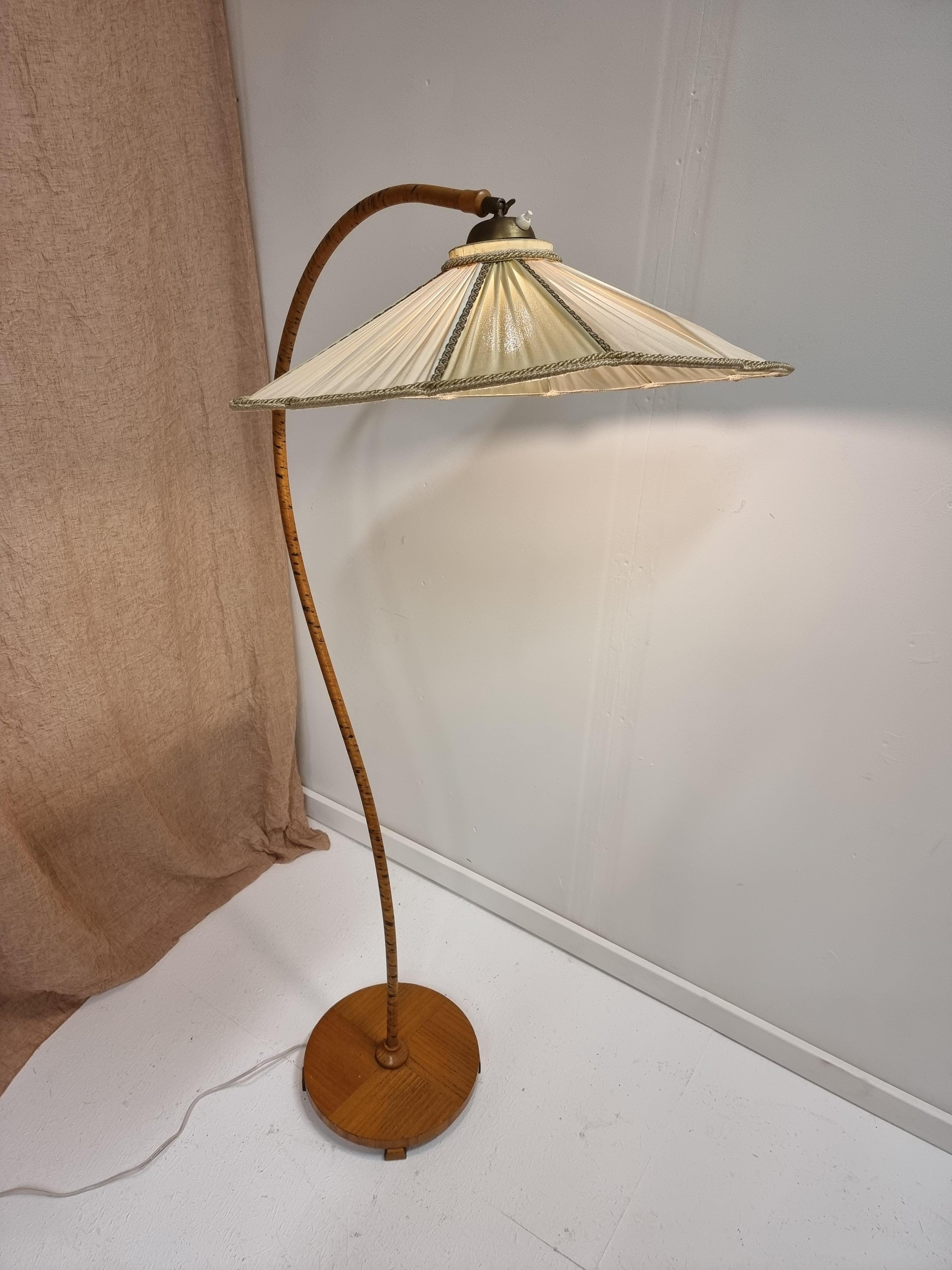 A rare Swedish Art Deco floor lamp with original lamp shade. Wooden S-shaped base. Original label: Aage Eriksson, Midskog. Stamped Made in Sweden.

In beautiful condition, lamp shade fabric with one smaller tear, and some discolorations. Beautiful