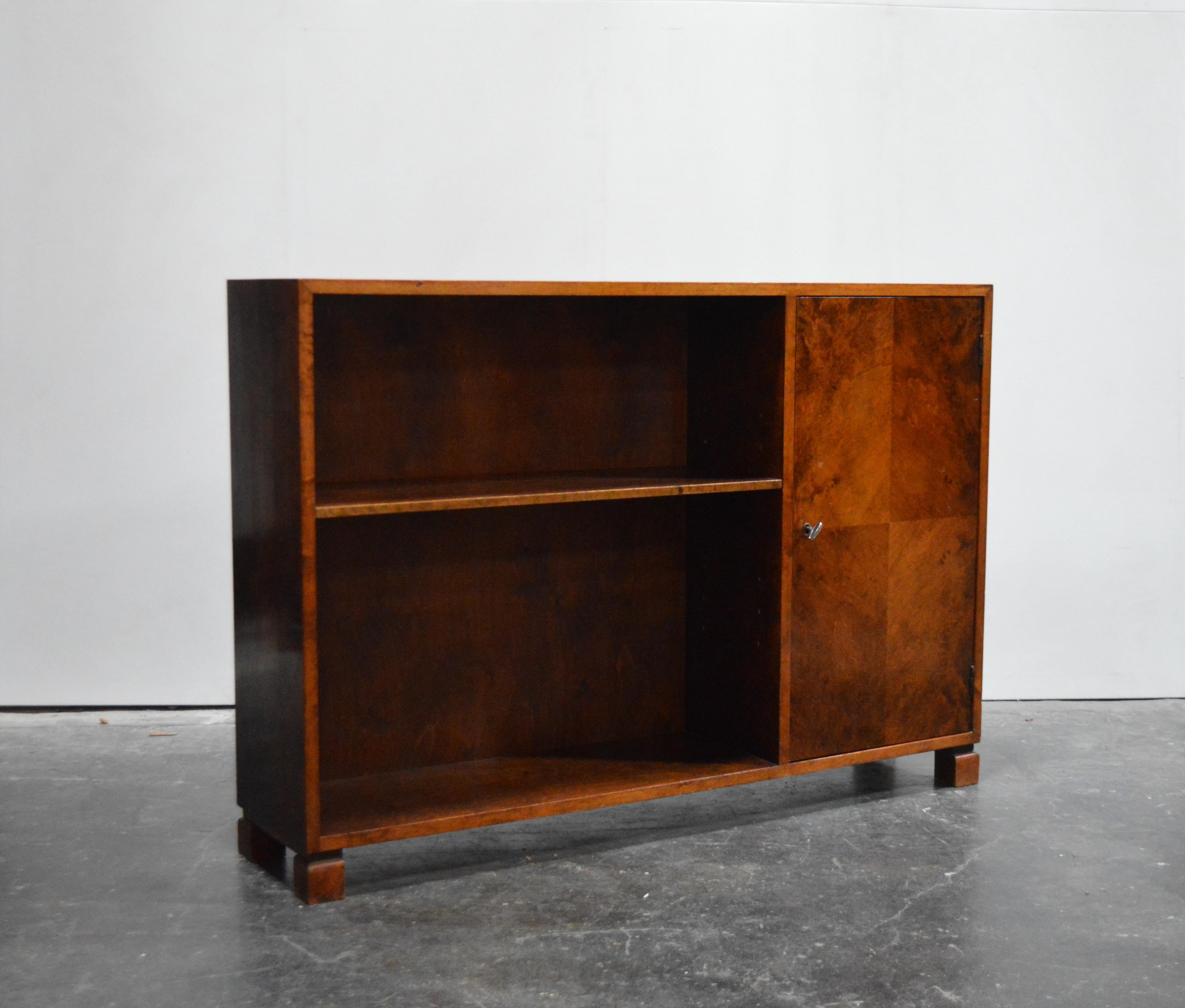 Midcentury or Art Moderne bookcase was cabinet crafted of native flame birch. This gorgeous wood has mellowed to a rich dark amber color. Adjustable shelf on the left and locking cabinet section on the right. Key included. Perfect as a slim console