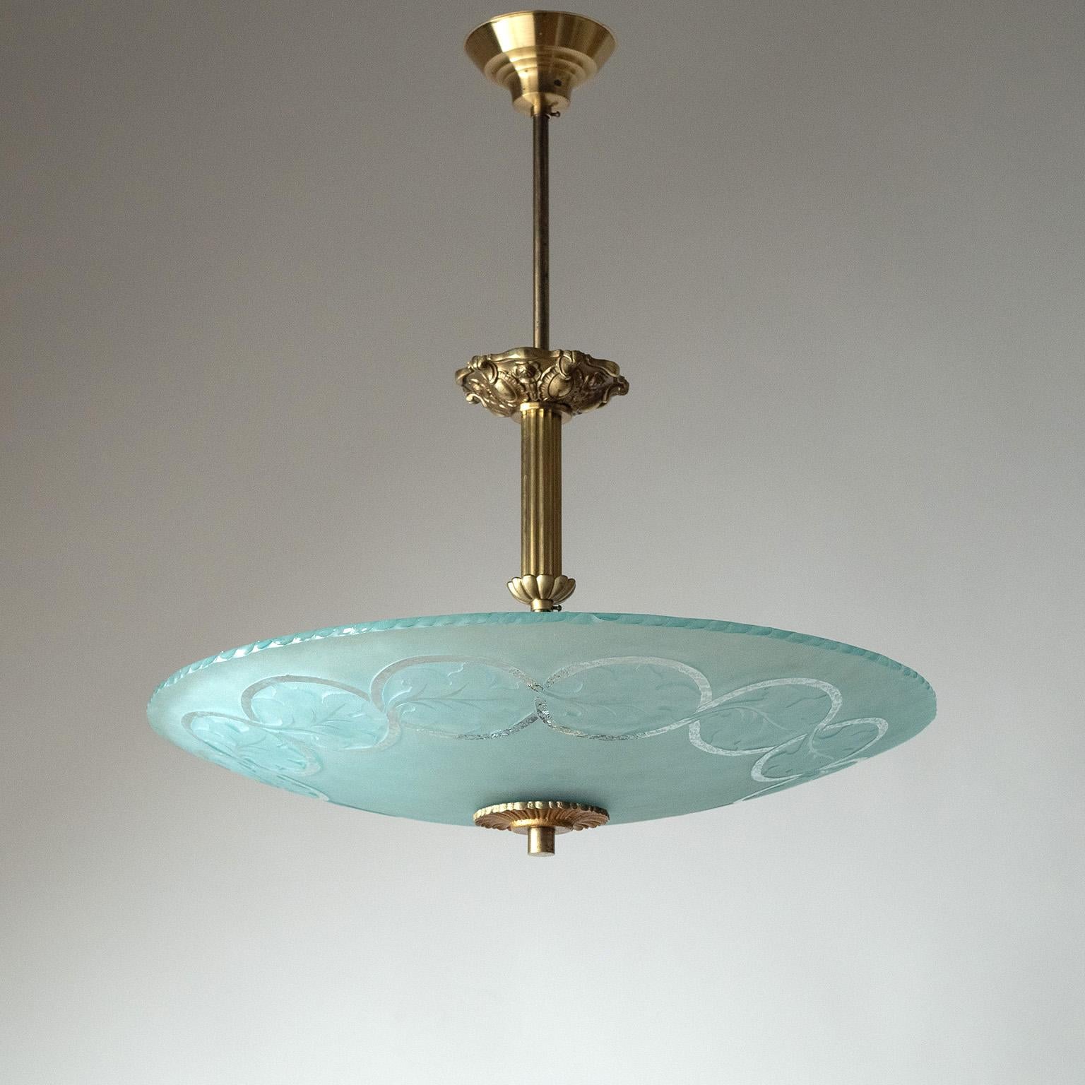 Lampadario svedese Art Deco in ottone e vetro degli anni 1930-1940. Struttura in ottone riccamente decorata con un grande diffusore in vetro curvato e testurizzato, parzialmente satinato, con bordo e decorazioni scheggiate. Condizioni originali
