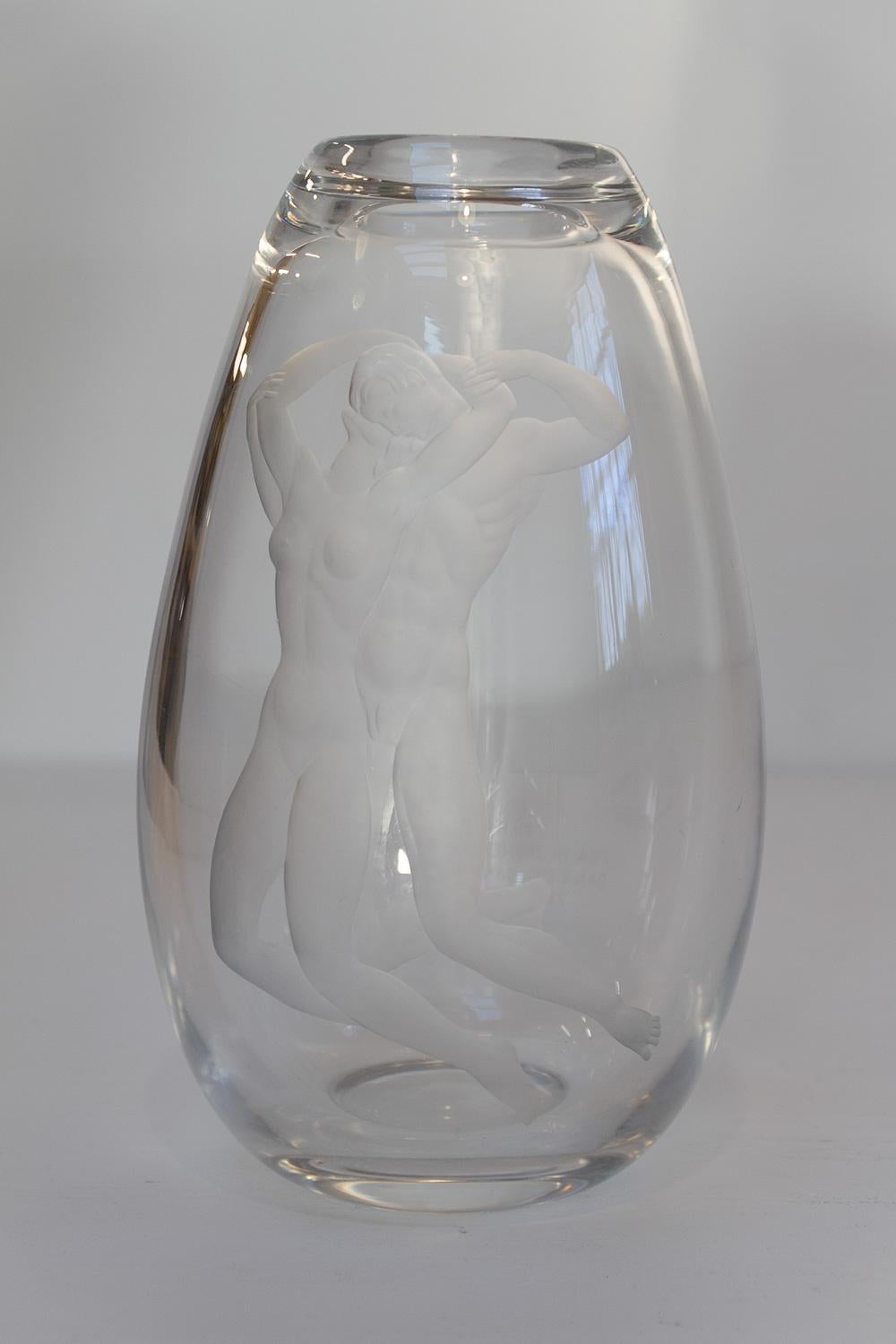 Vaso in vetro Swedish Art Glass con coppia di Vicke Lindstrand per Orrefors, 1930.

Grande e imponente vaso Art Deco trasparente con motivo inciso di una giovane coppia nuda che si abbraccia sott'acqua.  
Disegnato da Vicke Lindstrand e prodotto da
