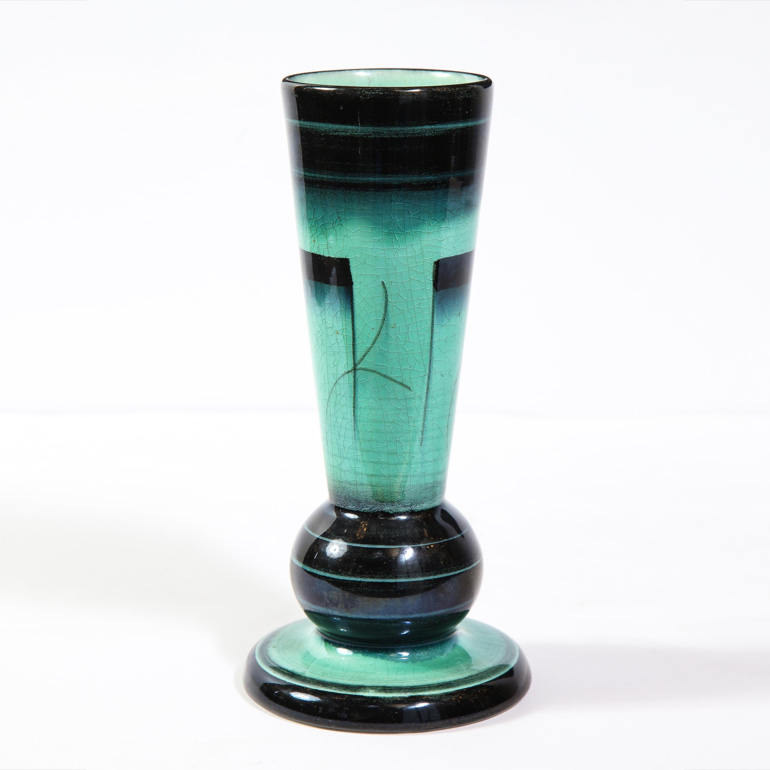 This elegant Art Deco glazed ceramic vase was designed by Ilse Claesson for Rörstrand in Sweden, circa 1930. It features a stylized hour glass form with a striated onyx glazed base and a sea foam center with abstract hand painted motifs, as well as