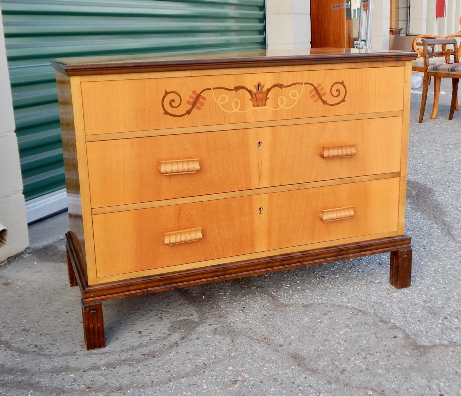 Swedish Art Deco inlaid chest of drawers rendered in elm with rosewood inlay. Top in highly figured golden flame birch wood. Three drawers. In great original condition with some age appropriate signs of wear. Ready to give a life time of good use.