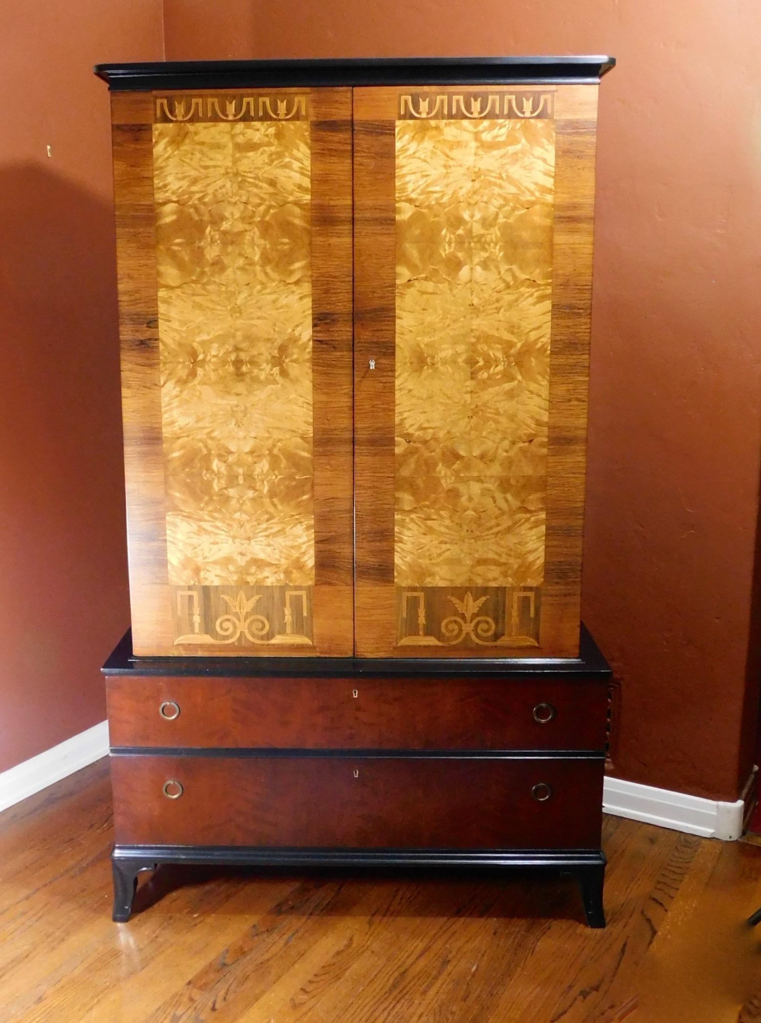 Superb Swedish Art Deco era inlaid storage cabinet crafted in book-matched, highly figured golden flame birch. Inlaid in rosewood, elm and pear woods.
These intricate neoclassical inlaid friezes are in Chambert's signature style.
Interior with two