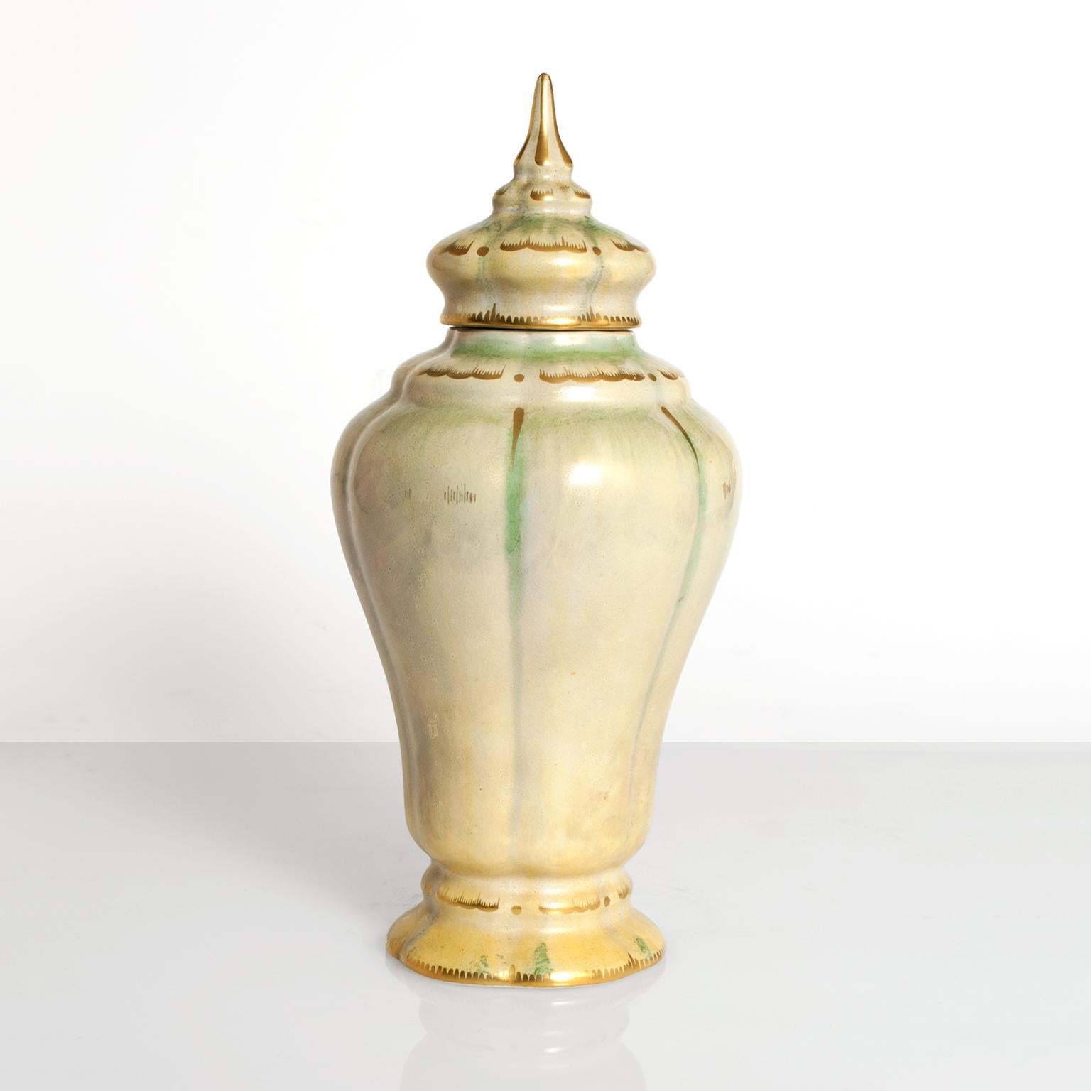 Swedish Art Deco, hand decorated ceramic vase with lid from Gustavsberg. Designed and signed by Josef Ekberg, 1920s, in pale green-yellow luster glaze with details in gold.
 
Measures: Diameter 6