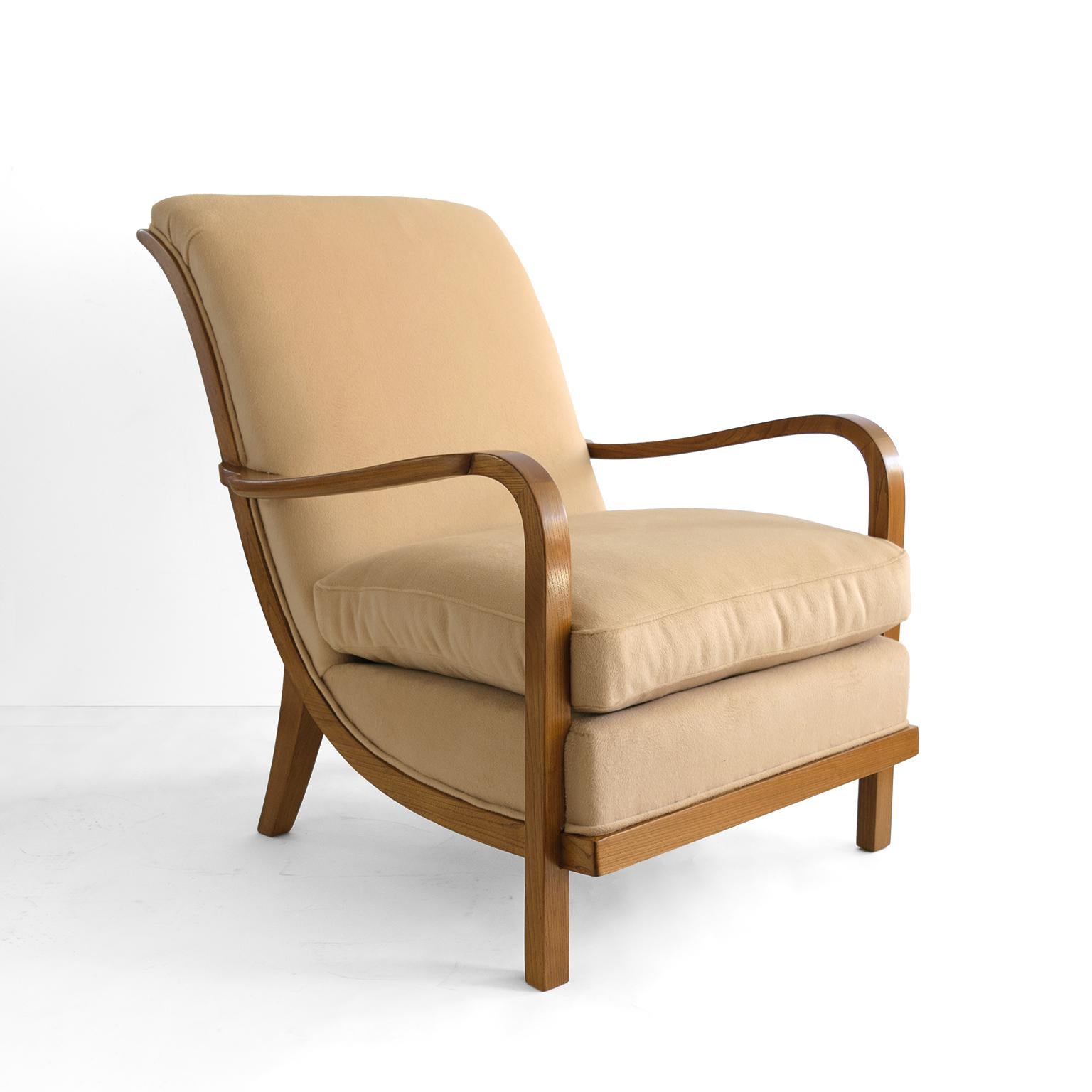 Elegant Swedish art deco armchair with a graceful scrolled back raised on sabre back legs. The chair is solid stained Elm and features a cantilevered platform seat with upholstered cushion. Produced by Wilhelm Knoll, Malmo, 1933. Newly refinished in