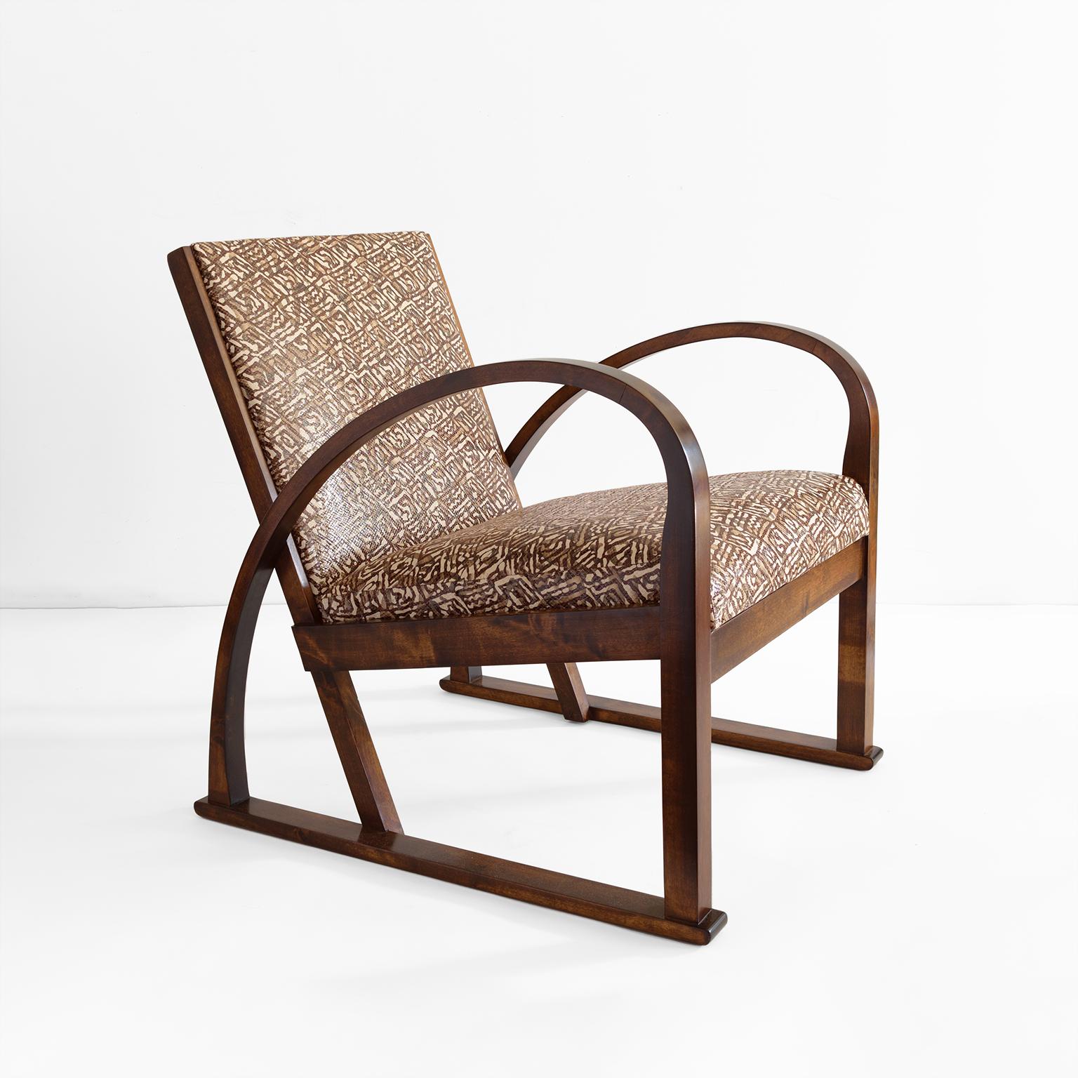 An early 1930’s Swedish modernist armchair designed by Axel Larson for S.F.M. Bodafors. Made of stained solid birch, the gracefully carved arms are beautiful as well as functional. The back and seat are newly upholstered in leather with a printed