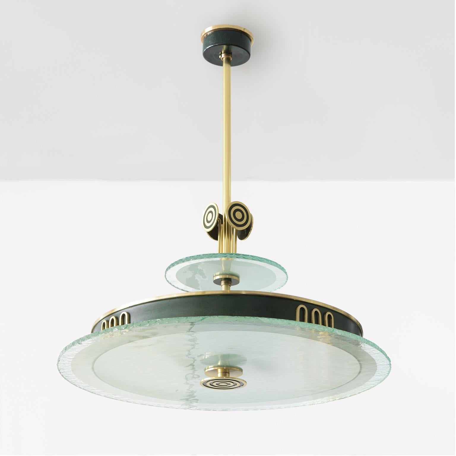 Swedish Art Deco patinated brass chandelier with polished brass details, made by Bohlmarks. Above the acid etch glass diffuser a stylized meander motif decorates the metal ring shade. A cluster of 4 modernist 