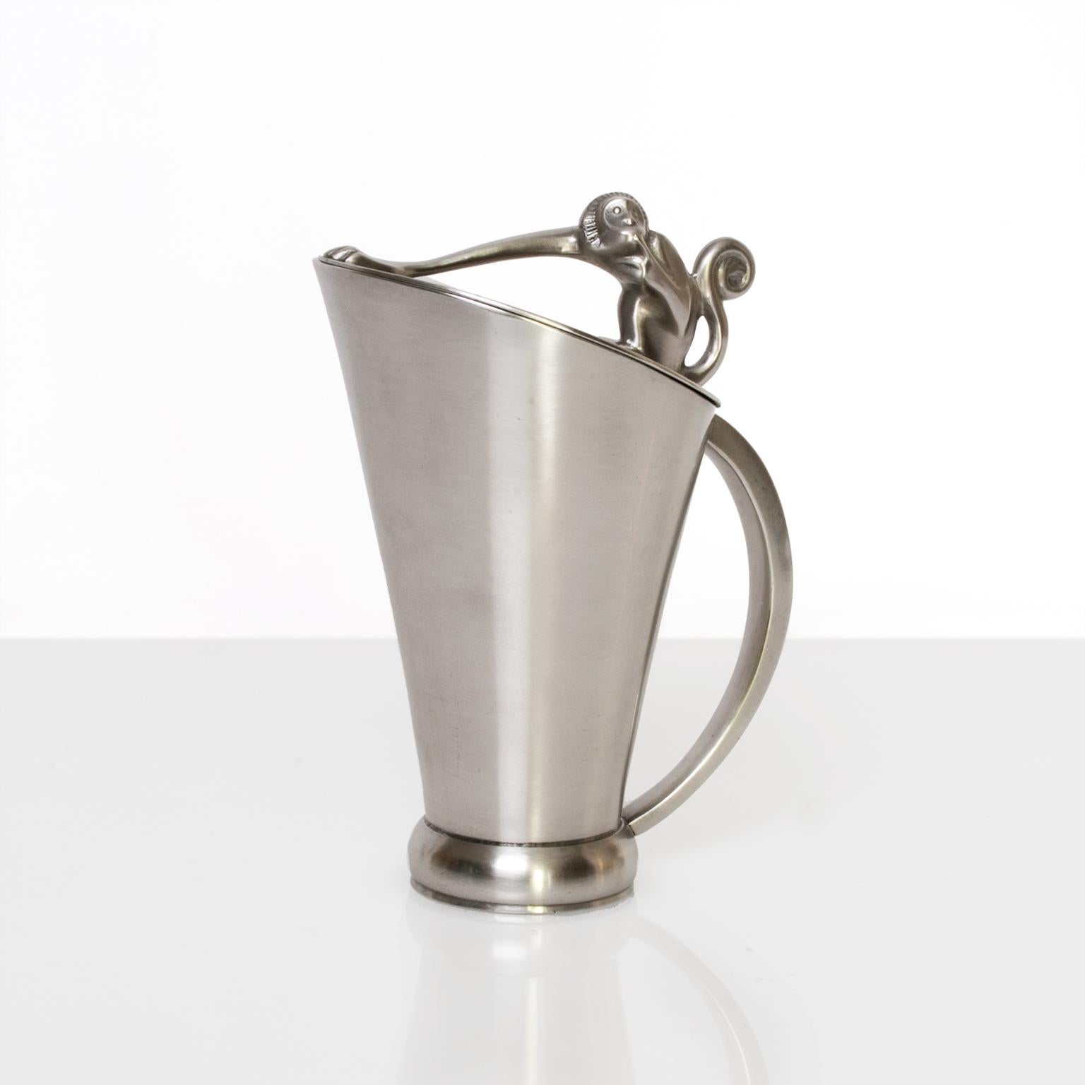 Swedish Art Deco solid pewter pitcher with a figure of a monkey sitting atop the lid, his outstretched arm serves as a handle. Made by GAB (Guldsmedsaktiebolaget) and stamped G8 (1933) made in Stockholm.
Measures: Height 16.5