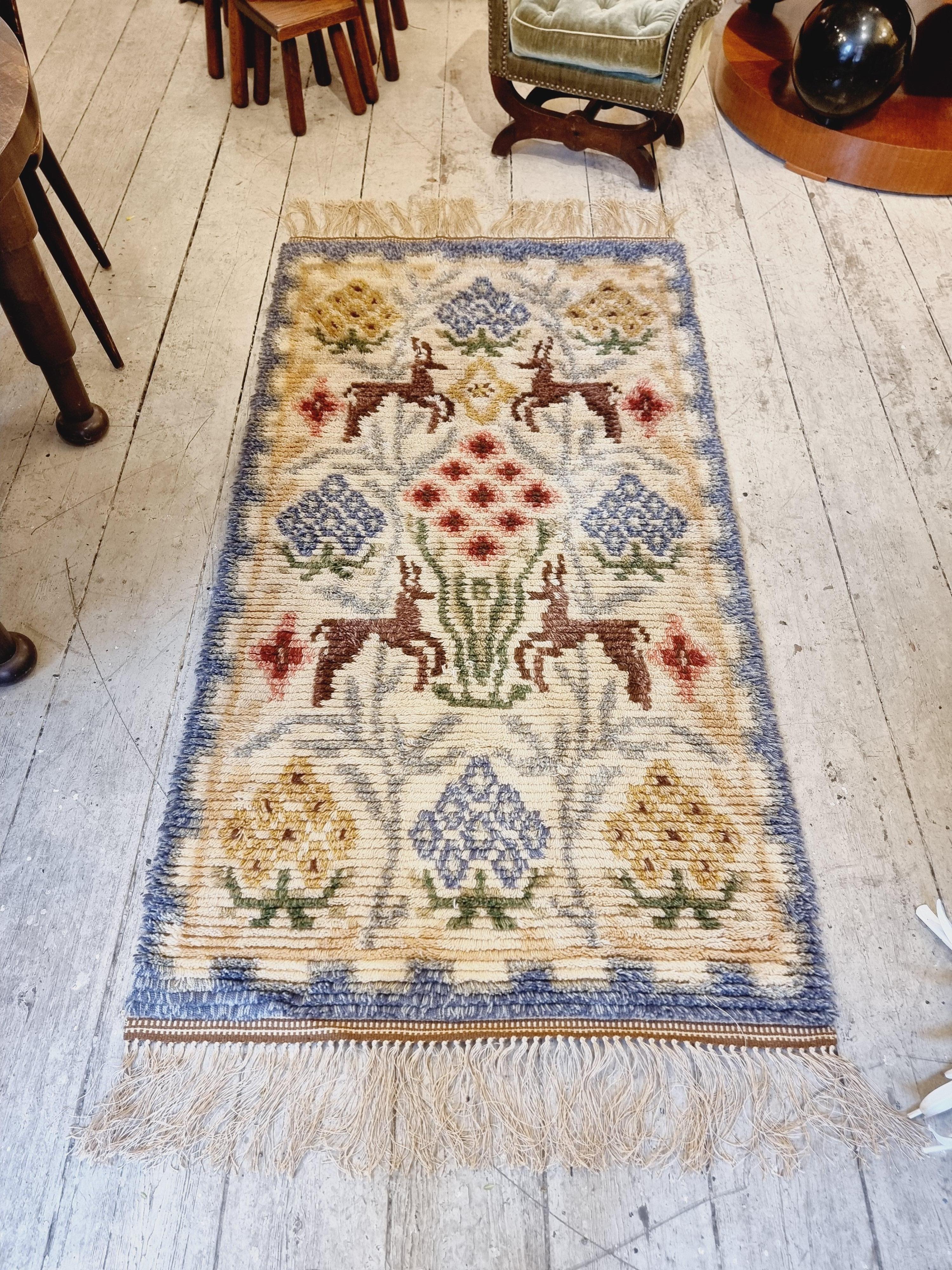 A  beautiful Swedish rya / shag rug, Art Deco / 1940s. With wall hangers, hardly any sign of use. 

Decor of flowers and reindeers. 

Length with fringe 210 cm,  excl. fringe 180 cm.