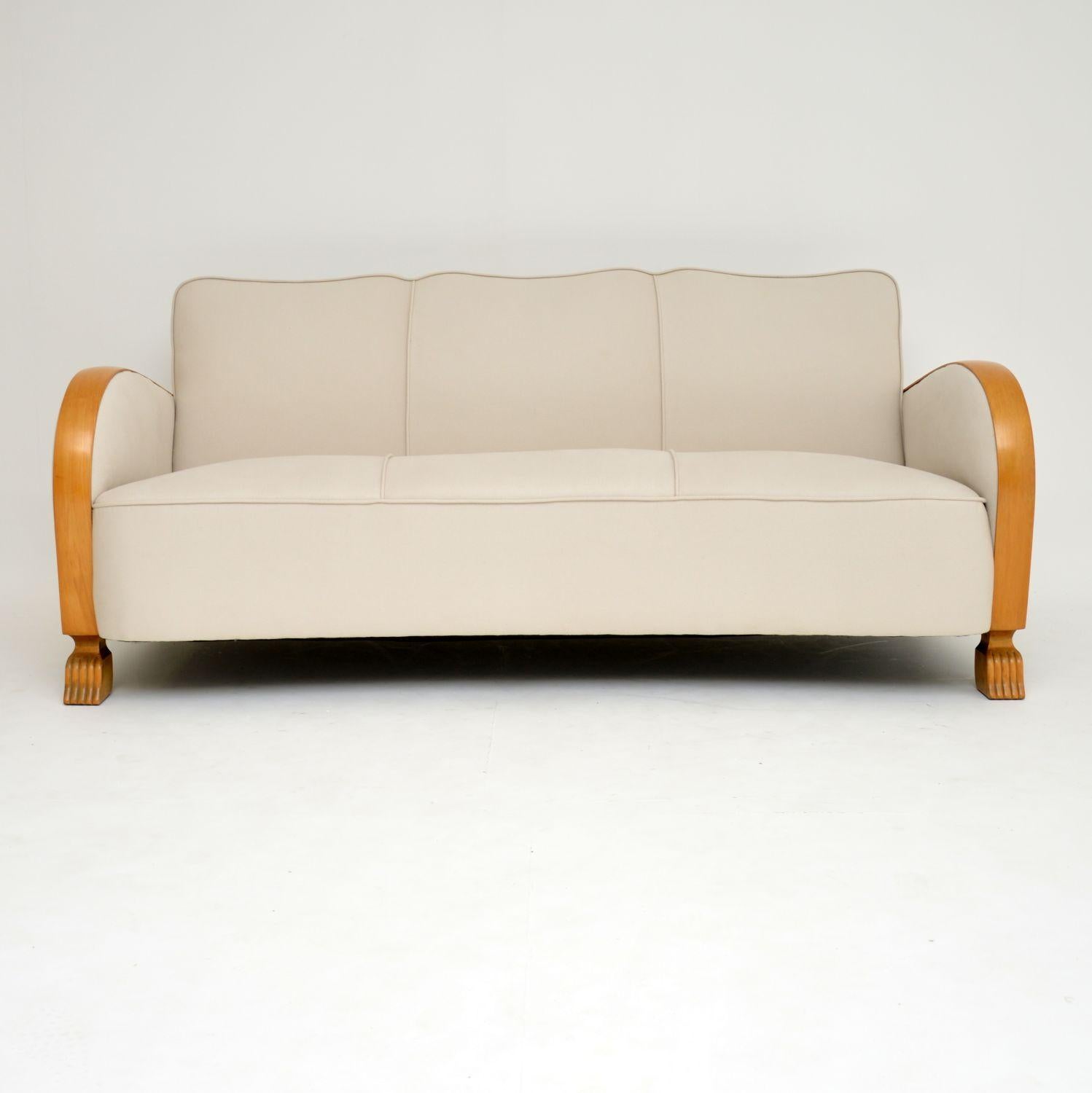 Very stylish original Swedish Art Deco three-seat sofa with satin birch arms and feet, dating to circa 1930s. It’s in excellent condition, having just been polished and re-upholstered in our regular cream cotton linen fabric. This sofa is also very